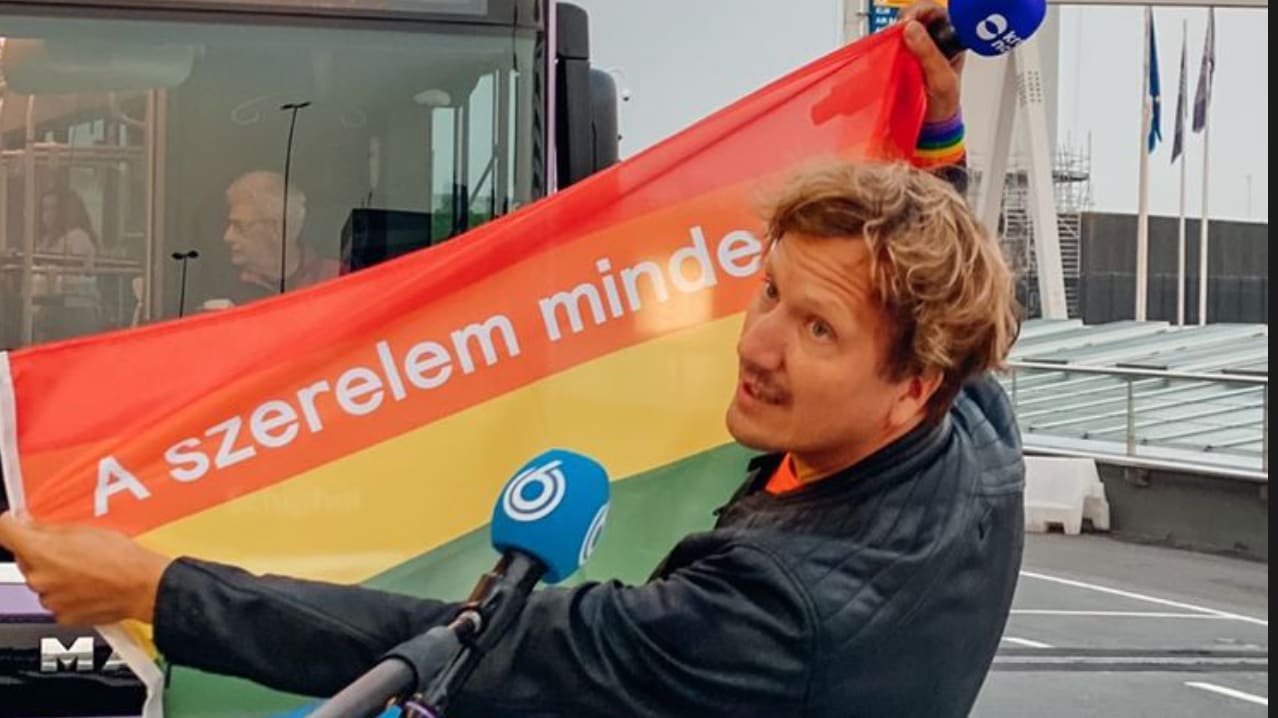 Klaas van Kruistum deelt regenboogvlaggen uit aan Oranjefans