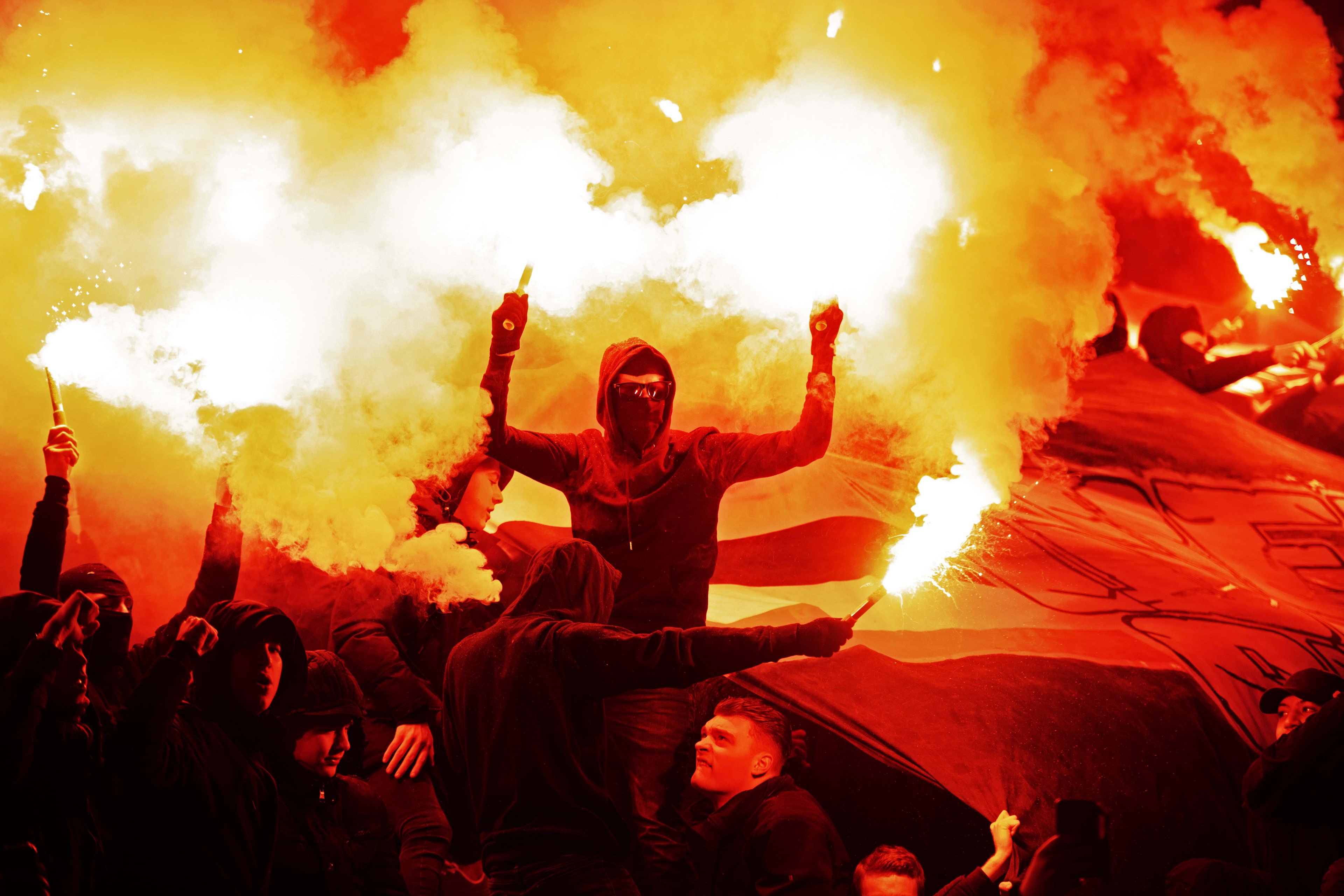 PSV-supporters steunen ploeg door afscheid met vuurwerk en fakkels