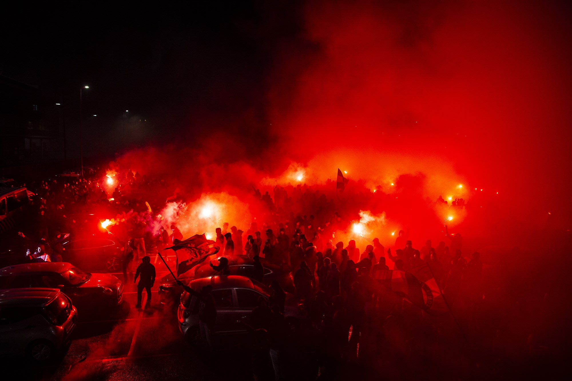 Honderden Feyenoord-supporters verzamelen zich met fakkels en vuurwerk voor de Kuip