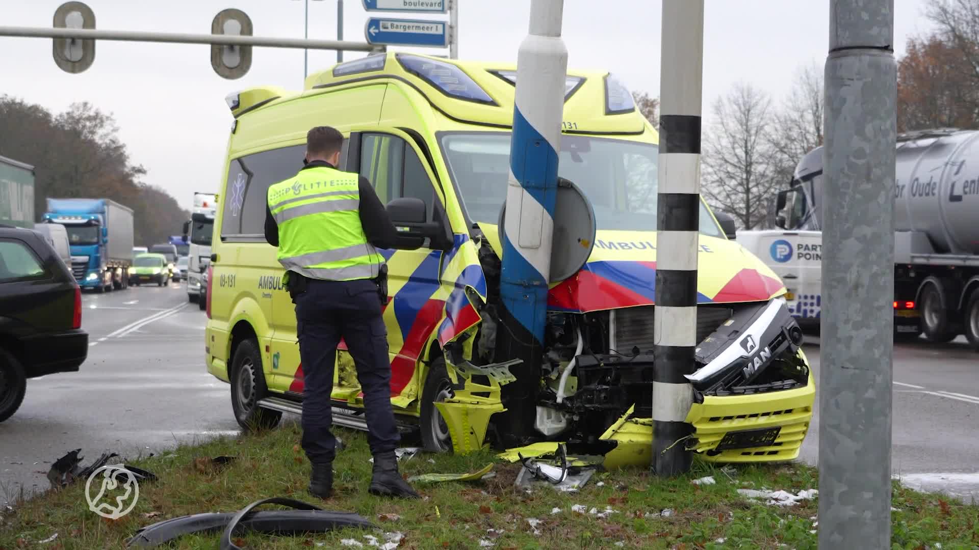 Ambulance botst met auto en knalt tegen verkeersmasten aan