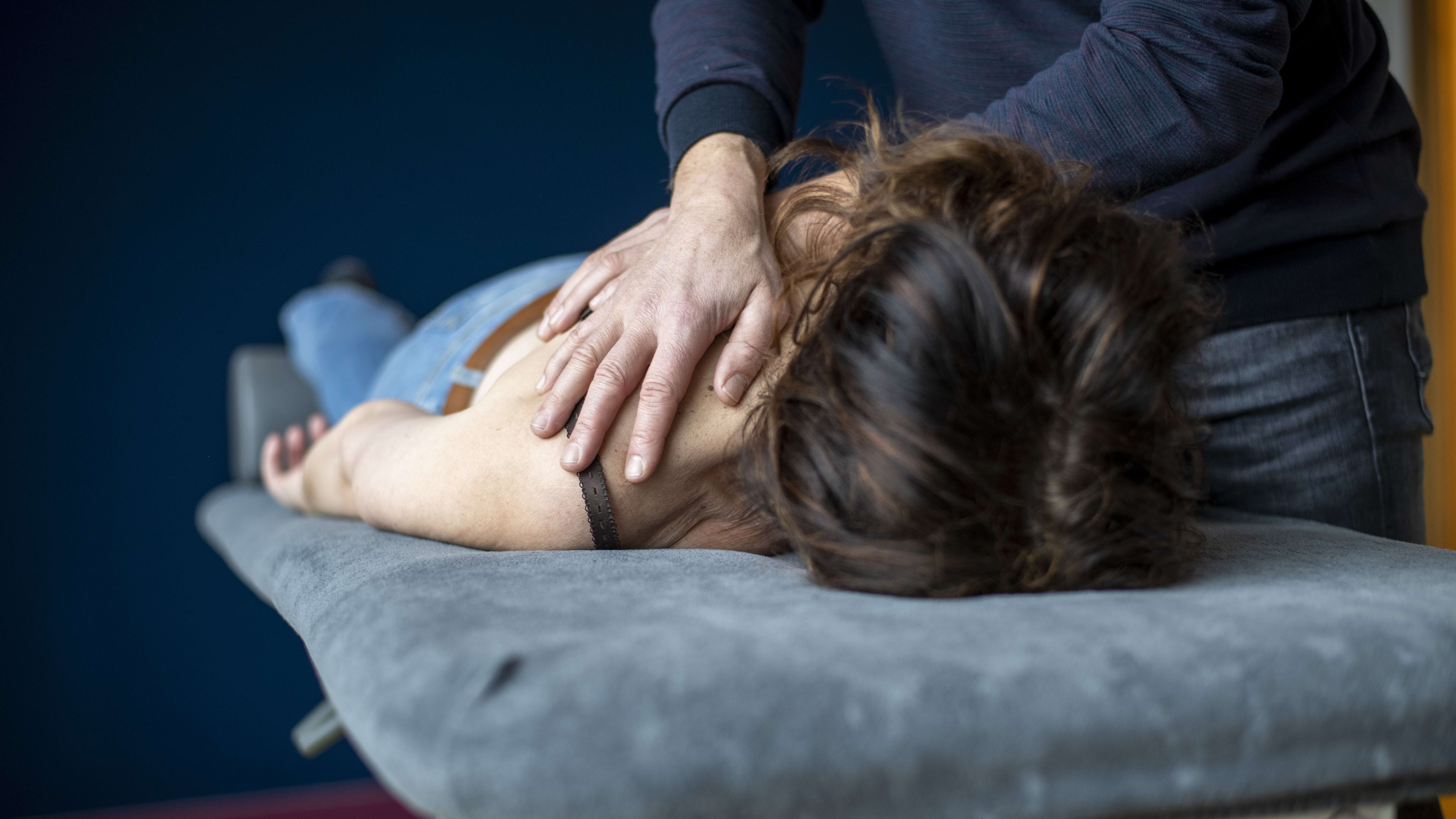 Fysiotherapeut betast, likt en zoent vrouw op massagetafel en wordt uit vak gezet