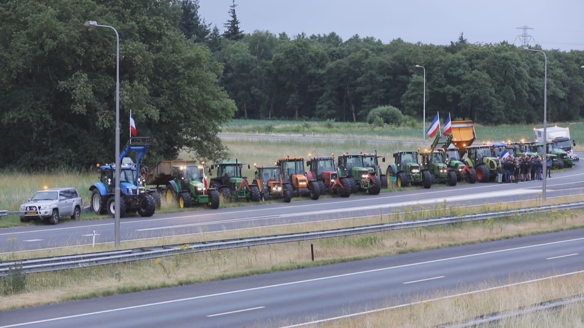 Tientallen boeren parkeren trekkers op en langs A50 bij Apeldoorn, lopen op snelweg