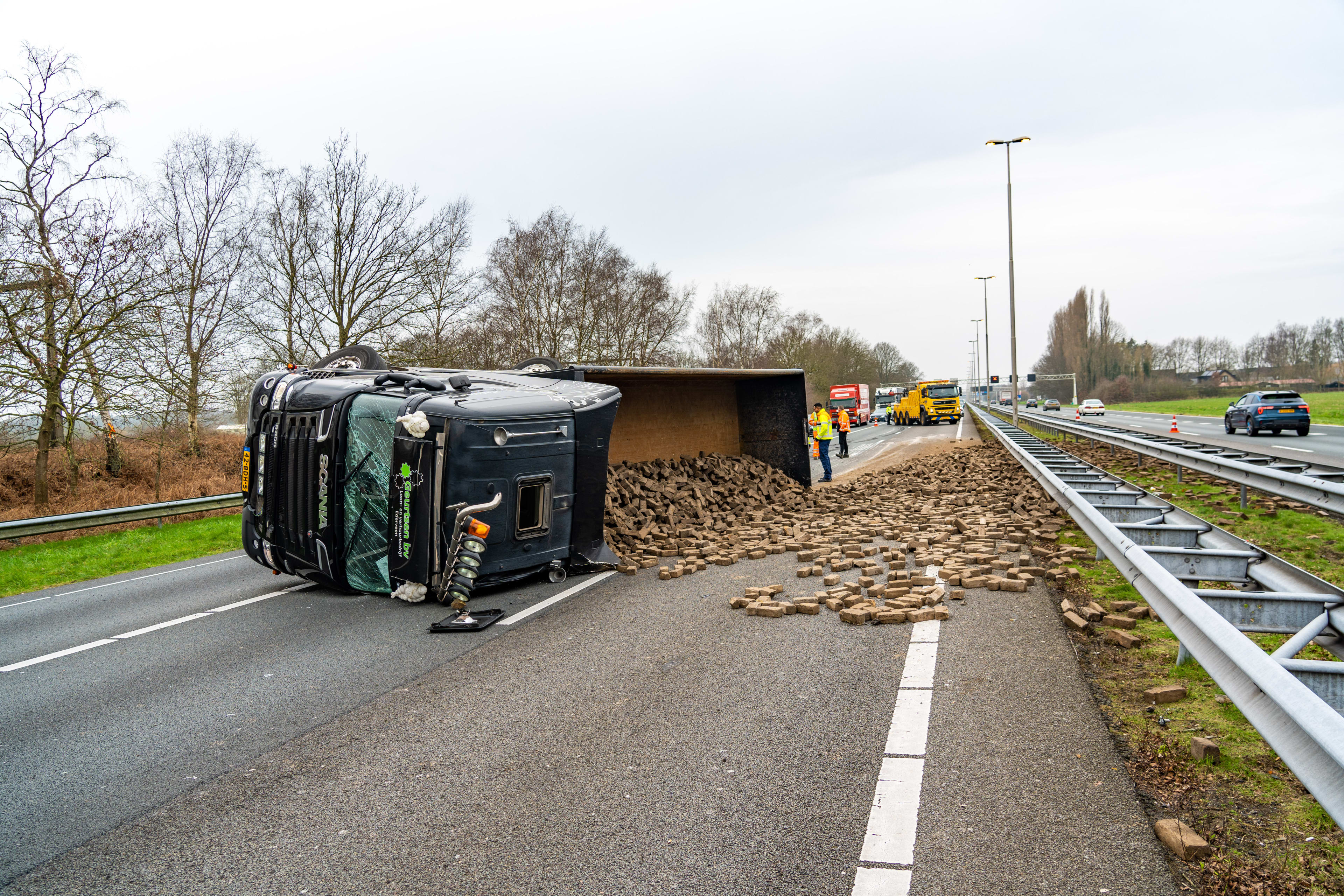 A1 bezaaid met duizenden bakstenen door gekantelde vrachtwagen