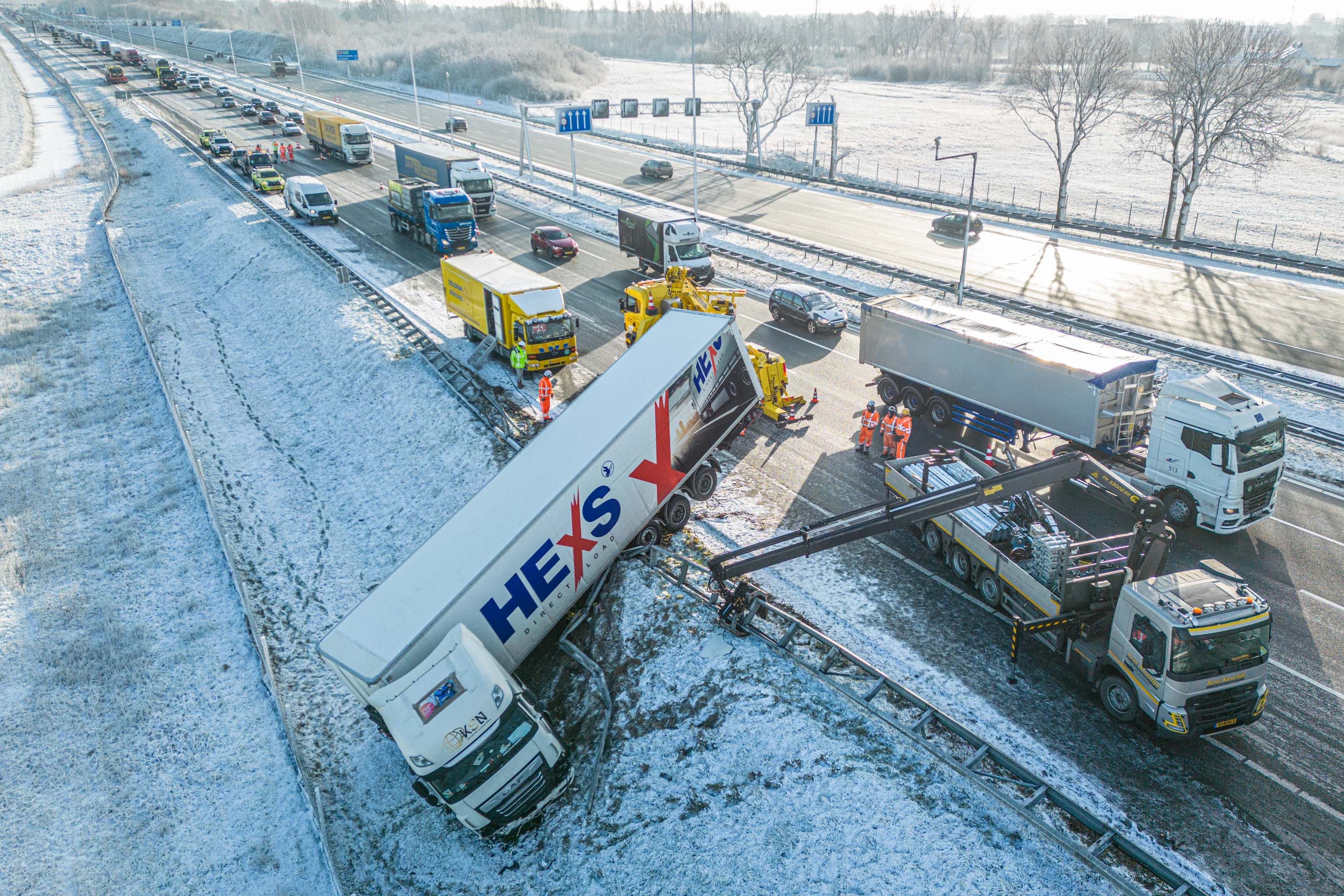 Vrachtwagen glijdt van de weg en schiet door vangrail op A12