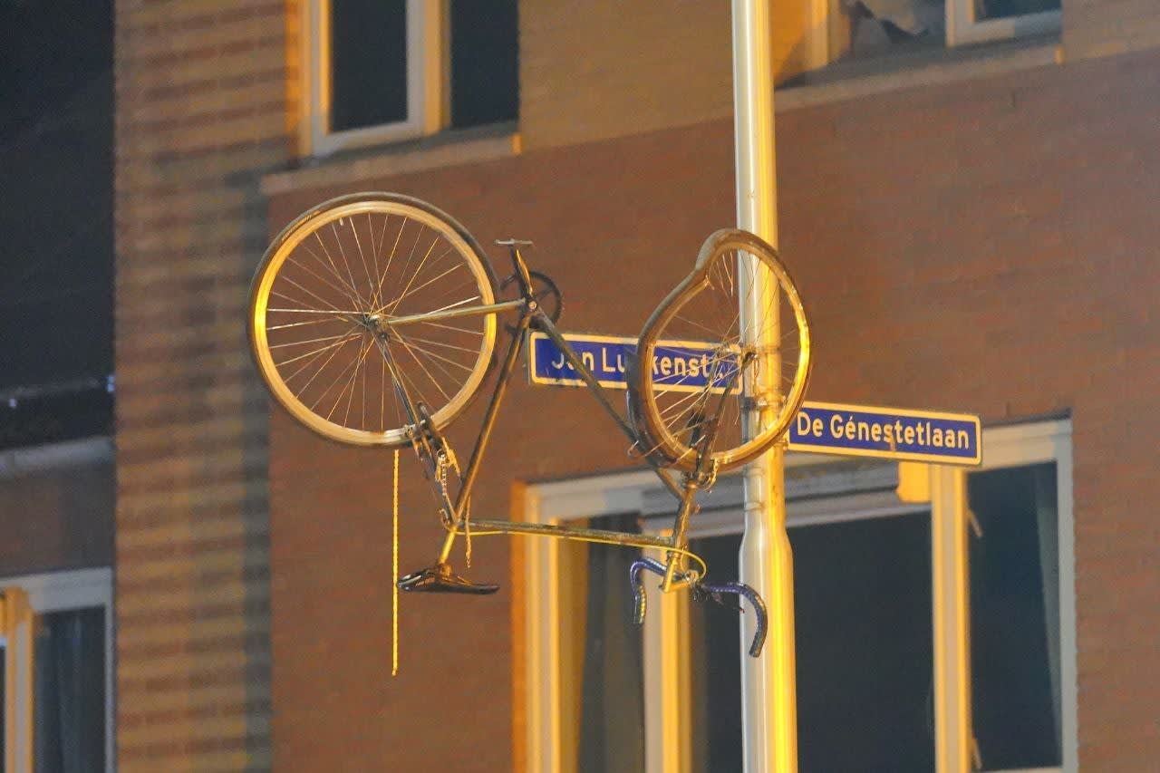 Fiets vliegt door de lucht na aanrijding en blijft hangen aan straatnaambordje