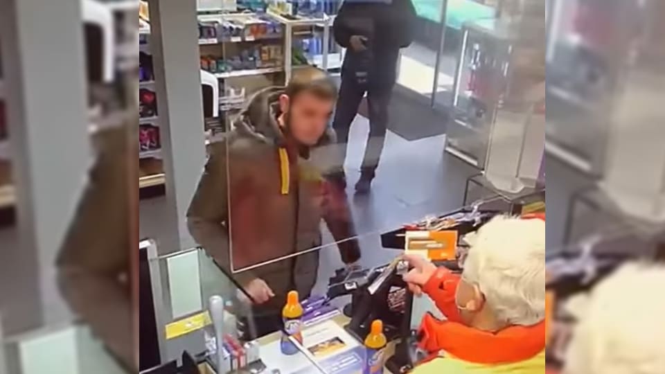 Agressieve mondkapweigeraar gooit vol blikje frisdrank door spatscherm bij tankstation