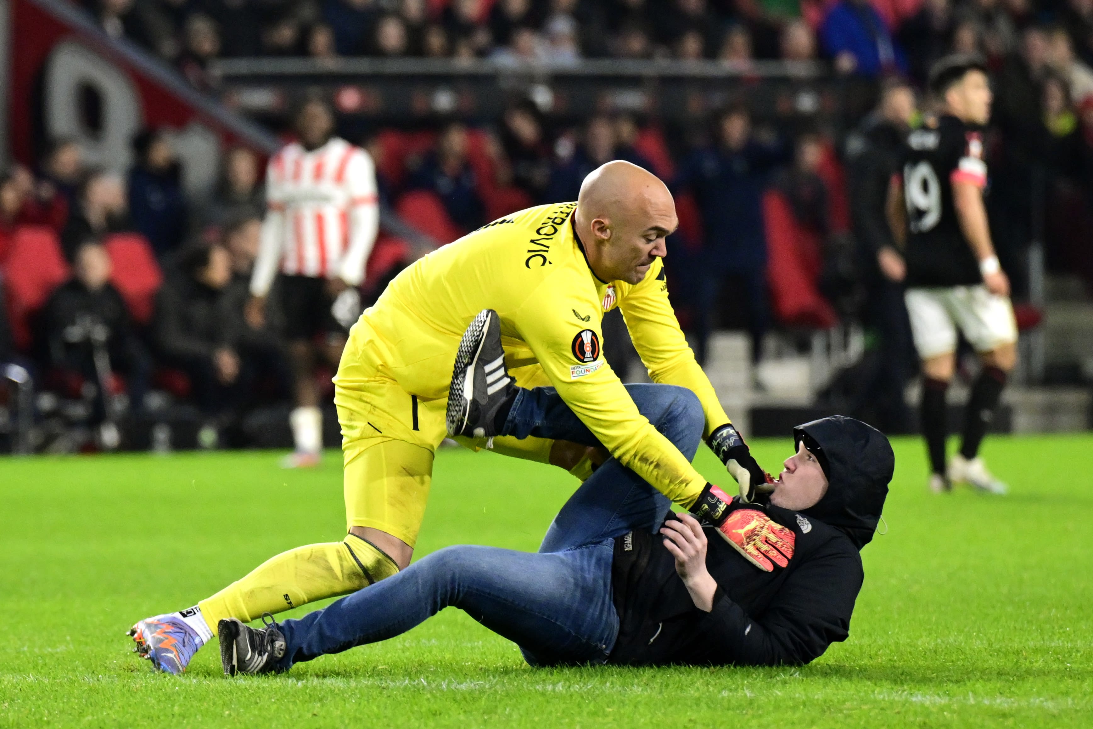 ZIEN: PSV-supporter rent veld op en valt keeper Sevilla aan