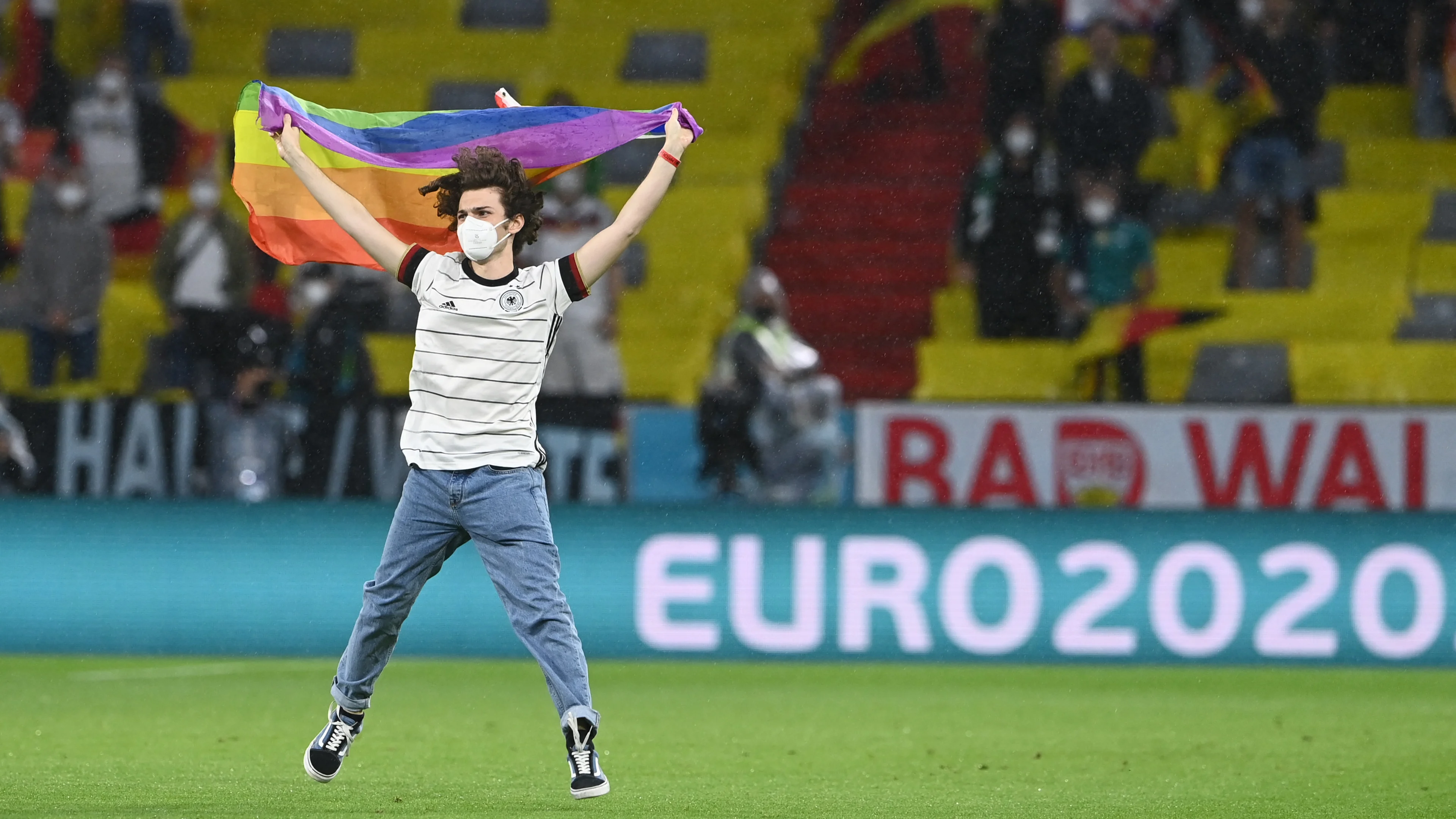 Demonstrant met regenboogvlag op het veld bij Hongaars volkslied