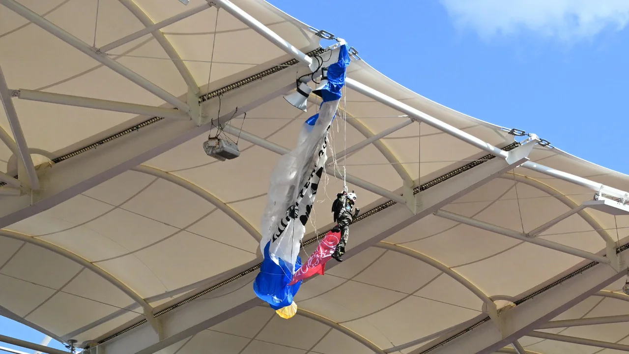 Rugbywedstrijd uitgesteld nadat parachutist met wedstrijdbal vastzat aan dak stadion