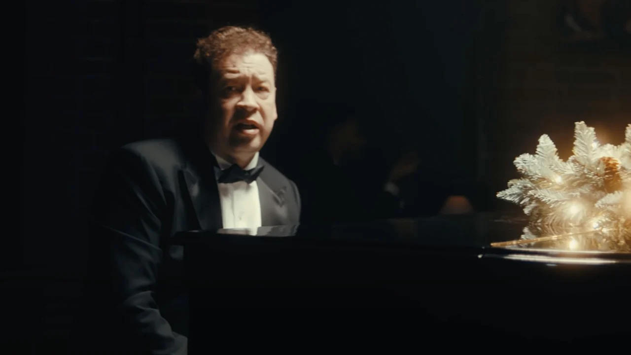 Leonid Slutsky zingend achter piano voor kerstboodschap van Rubin Kazan