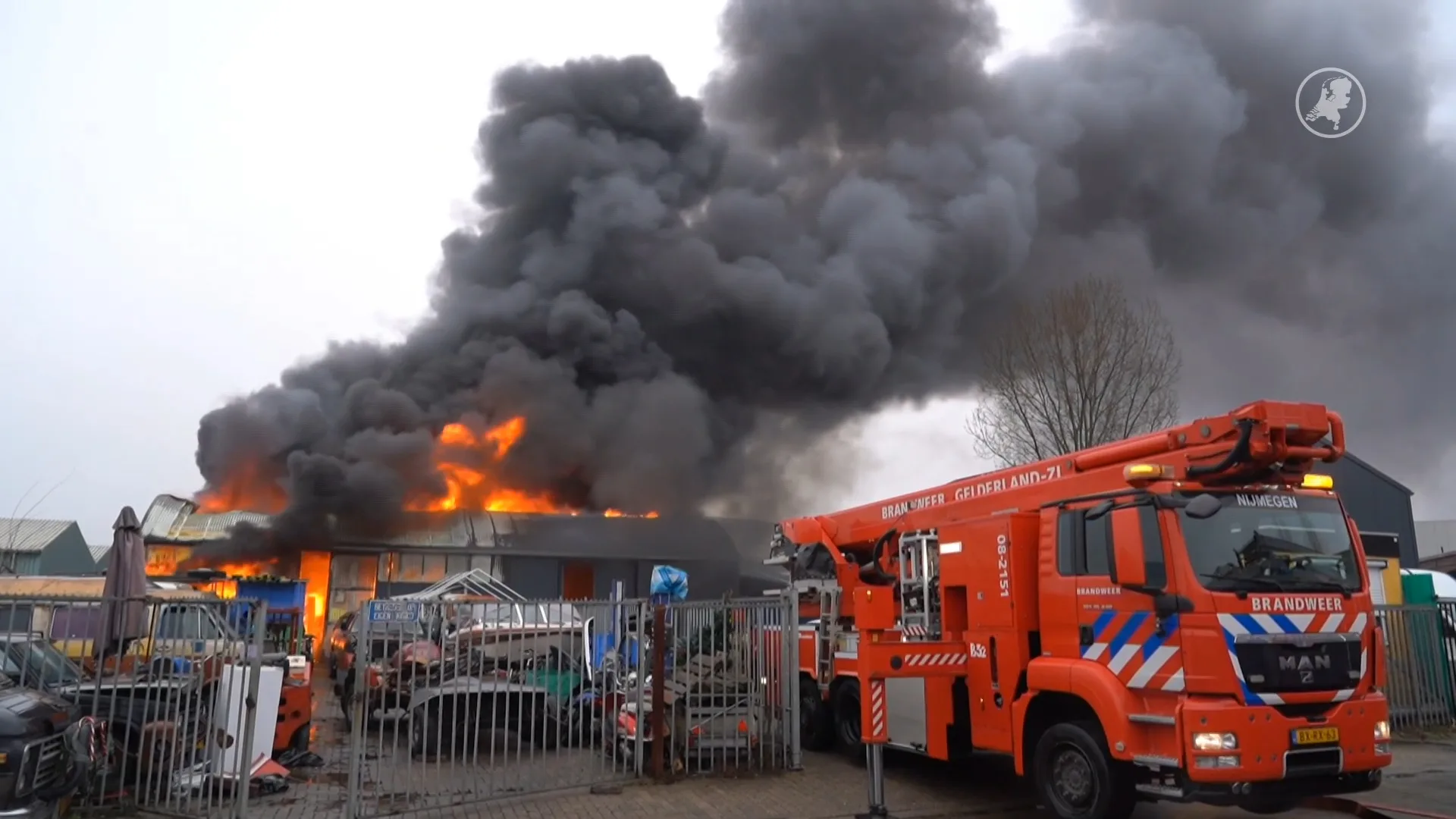 Vlammen slaan uit het dak bij brand loods autosloopbedrijf in Nijmegen