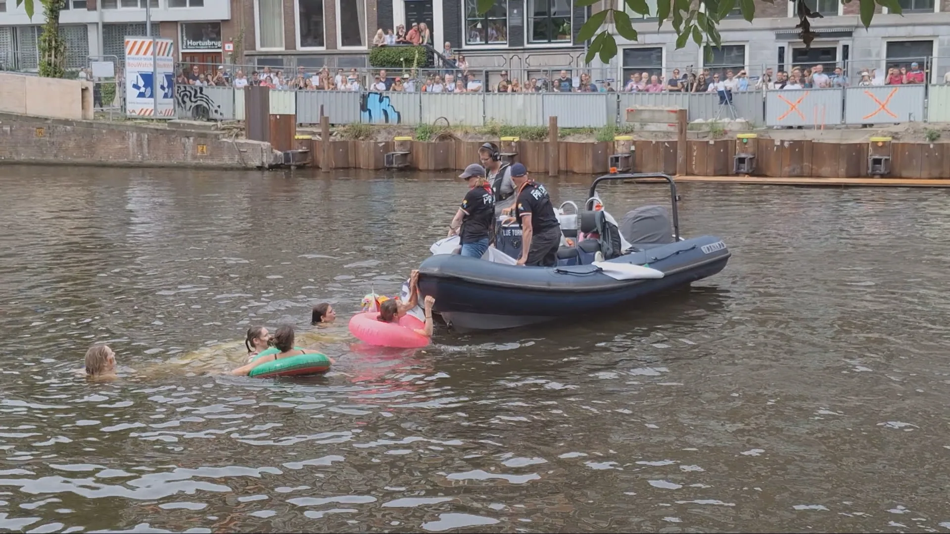Zwemmende demonstranten blokkeren boot tijdens Canal Parade