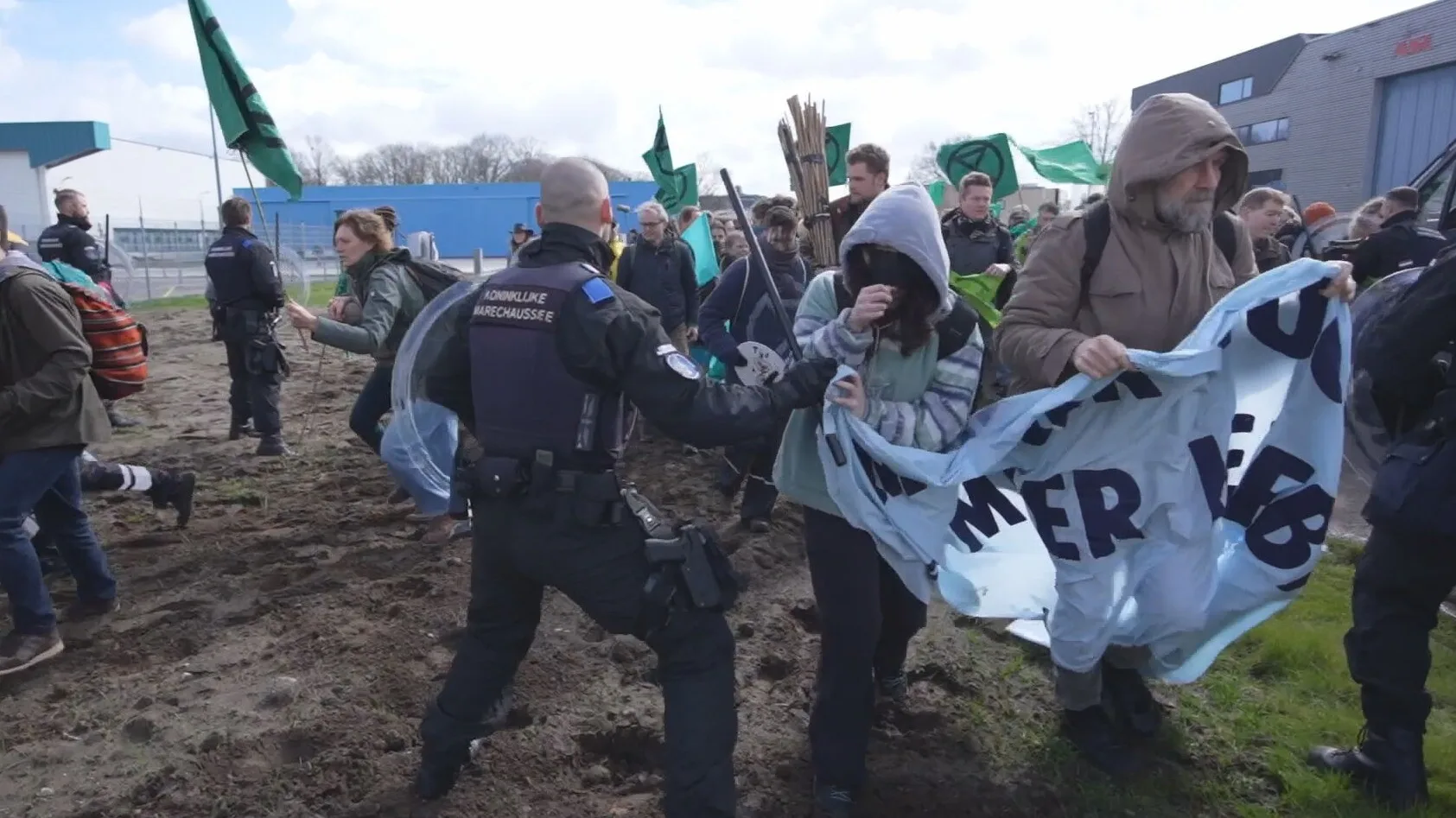 Klimaatdemonstranten door omheining Eindhoven Airport, marechaussee in actie