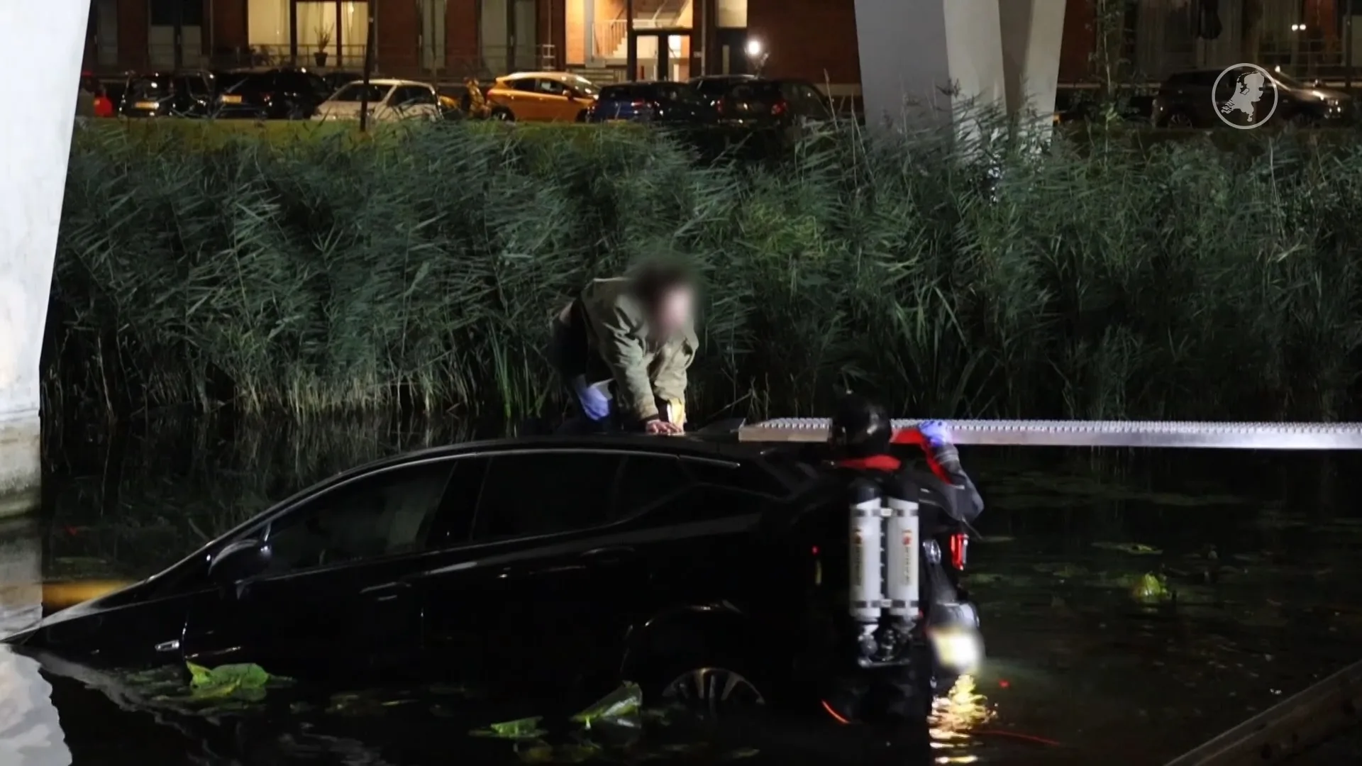 Hulpdiensten bevrijden vrouw van dak auto in water Rotterdam