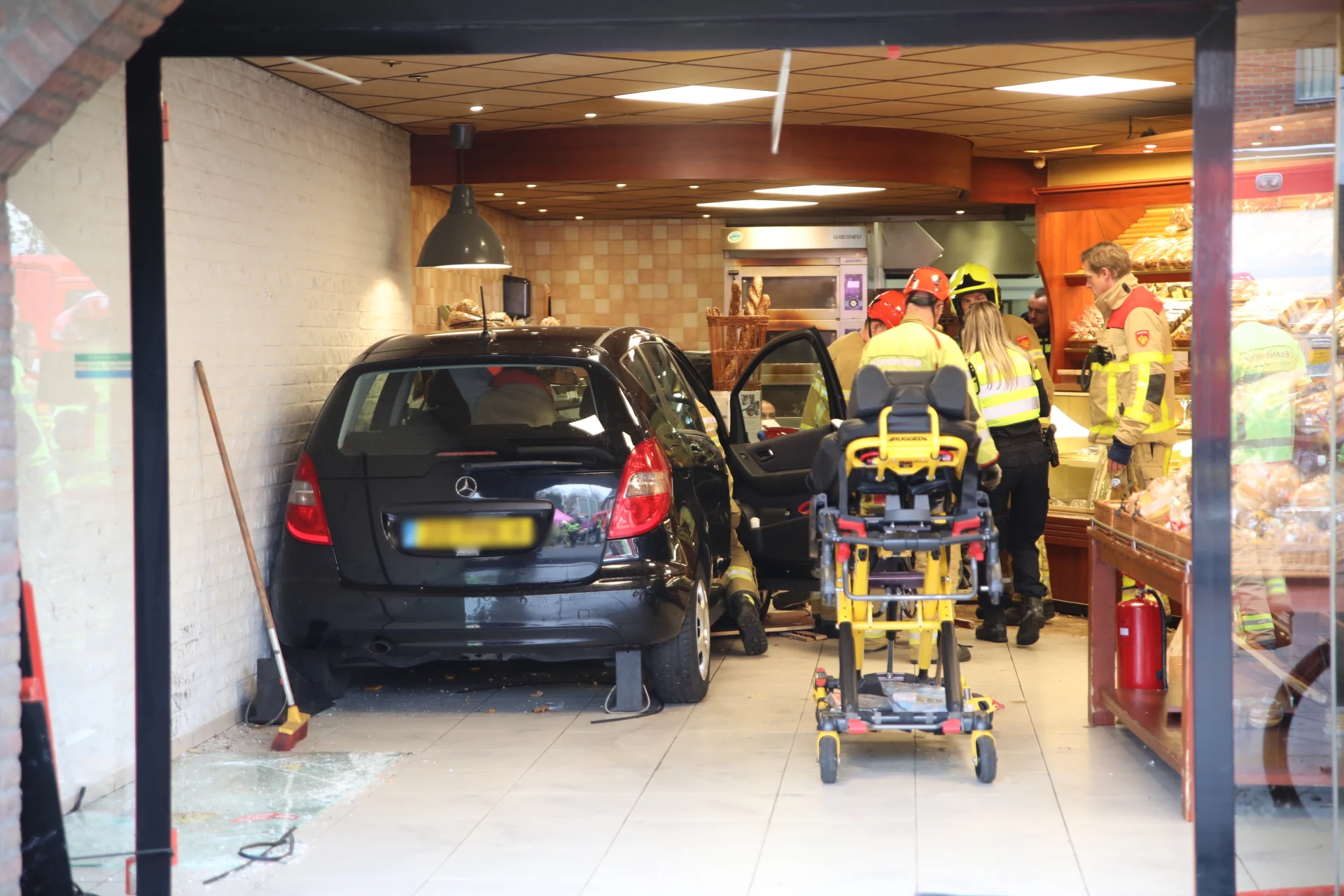 Auto rijdt dwars door pui van bakkerij in Ugchelen, vier klanten gewond