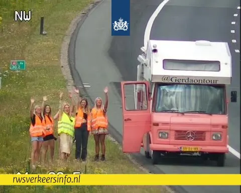 Even zwaaien naar de camera: dames houden de sfeer er goed in ondanks autopech