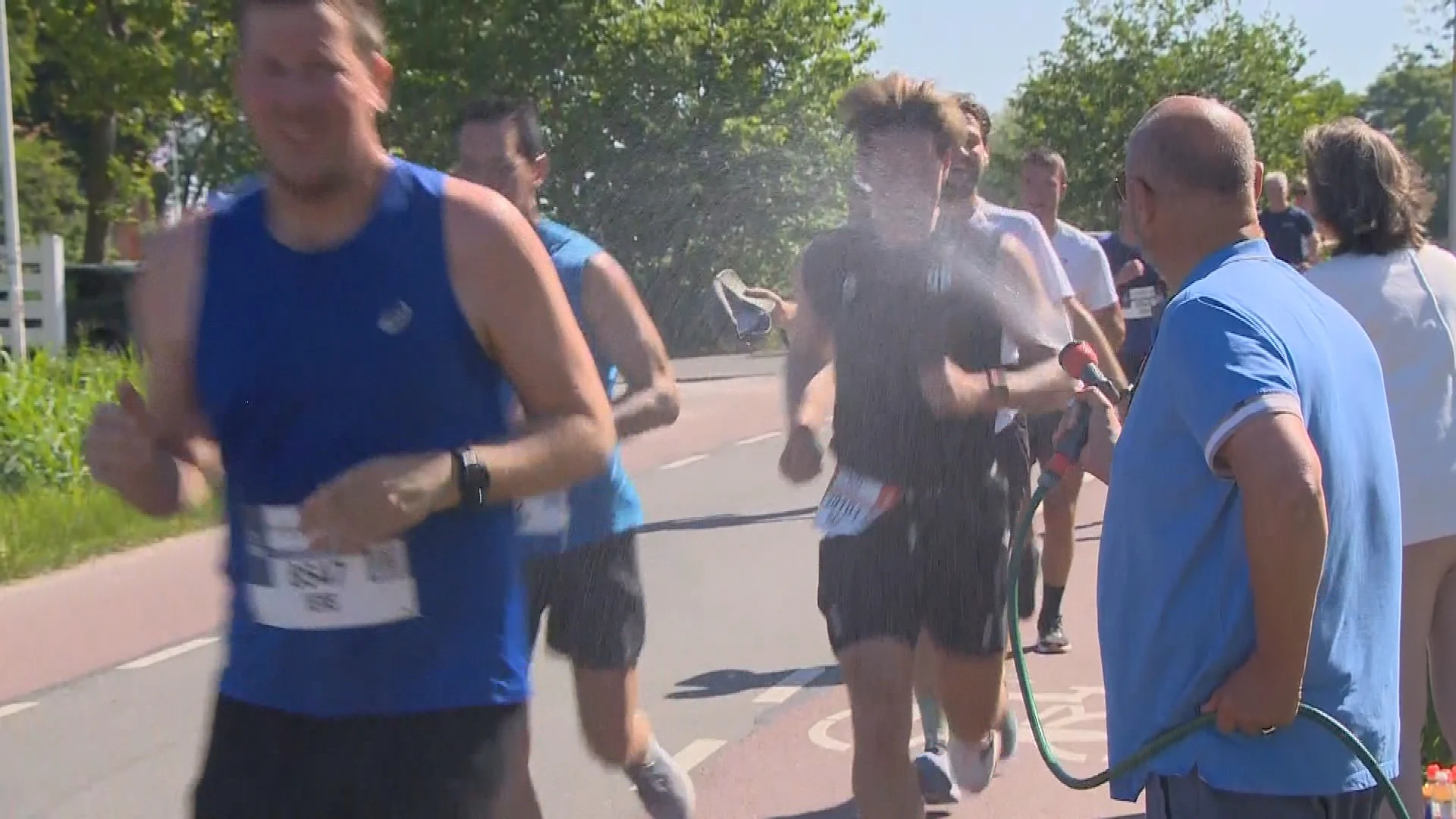 Bewoners met tuinslangen zorgen voor verkoeling tijdens marathon in Leiden