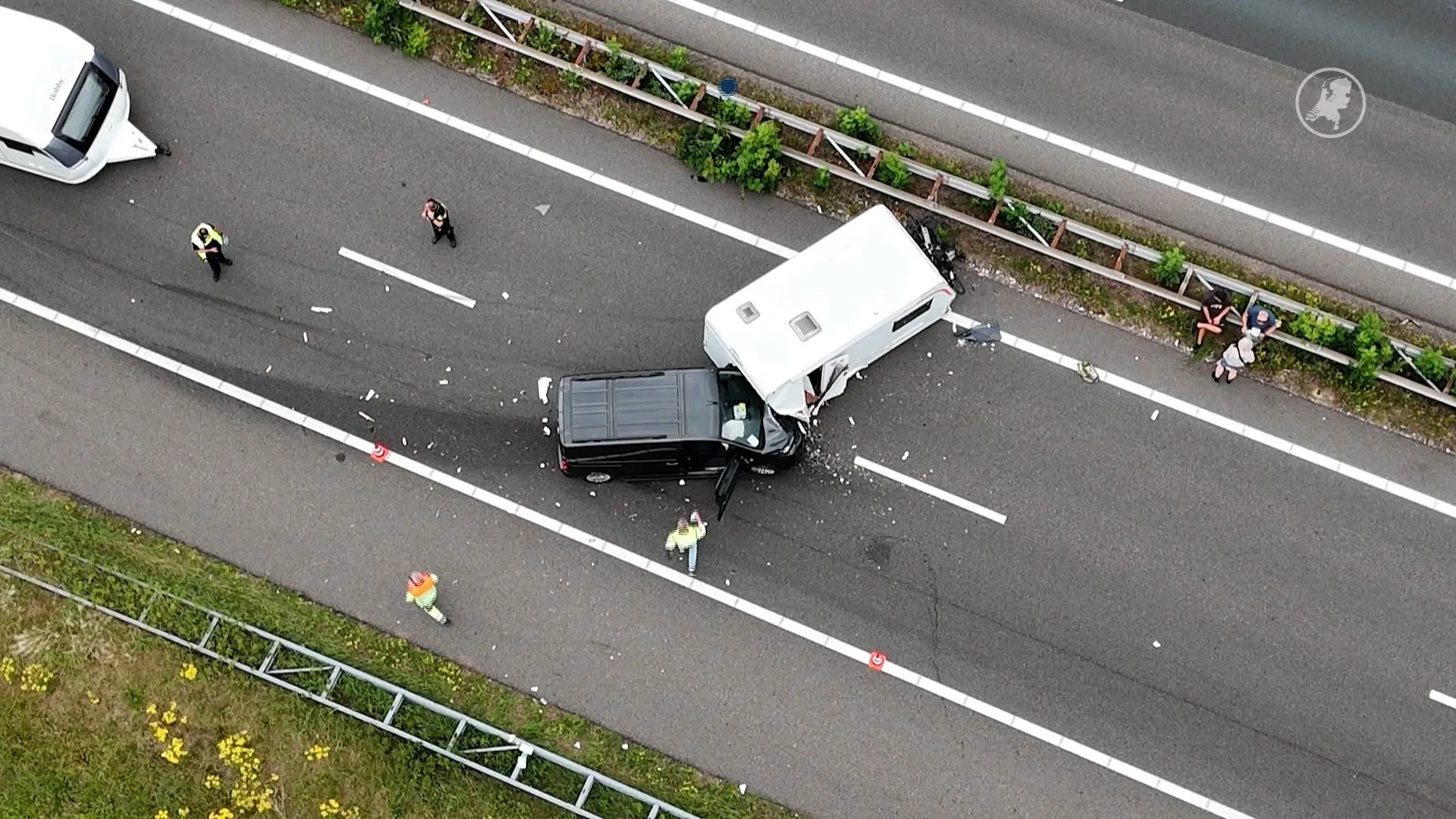 Auto botst op caravan, papieren worden ingevuld aan campingtafel op snelweg