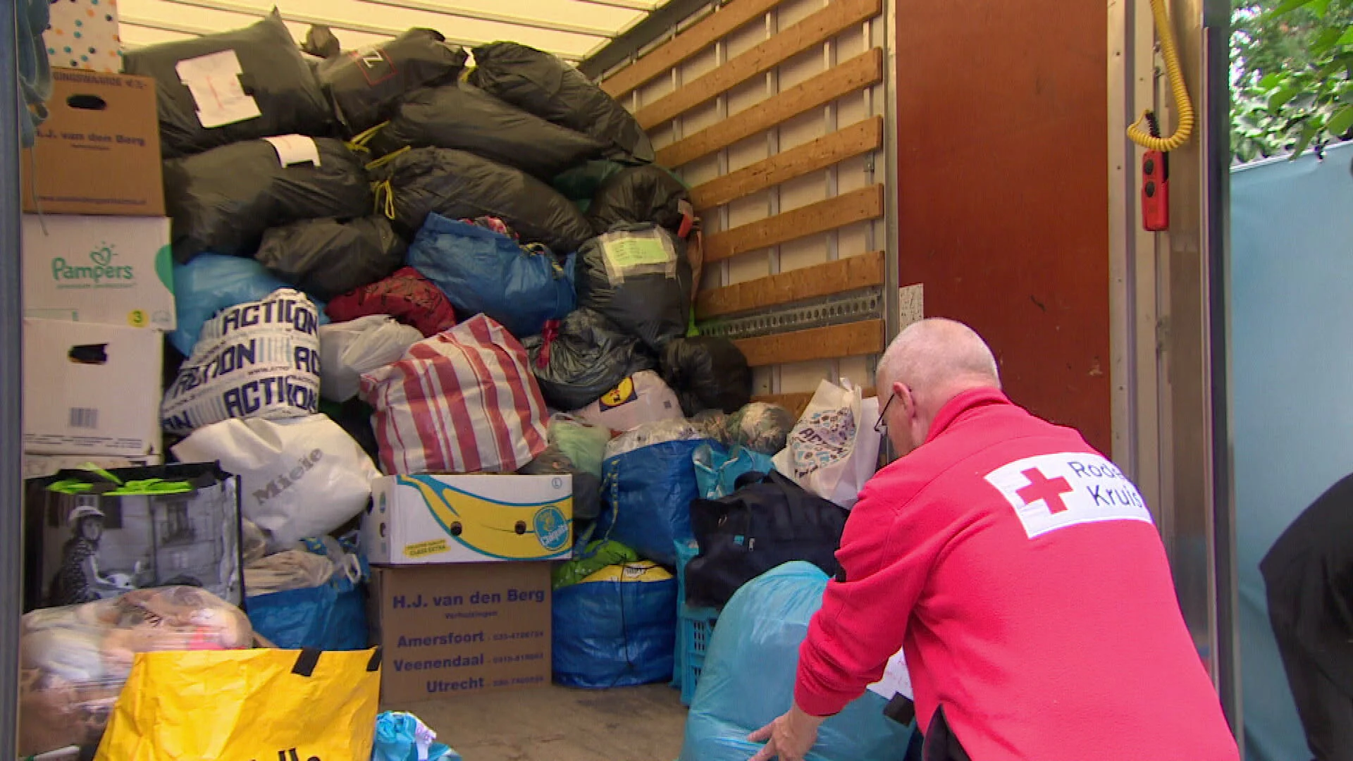 Vrijwilligers Rode Kruis sorteren gedoneerde kleding voor Afghaanse vluchtelingen