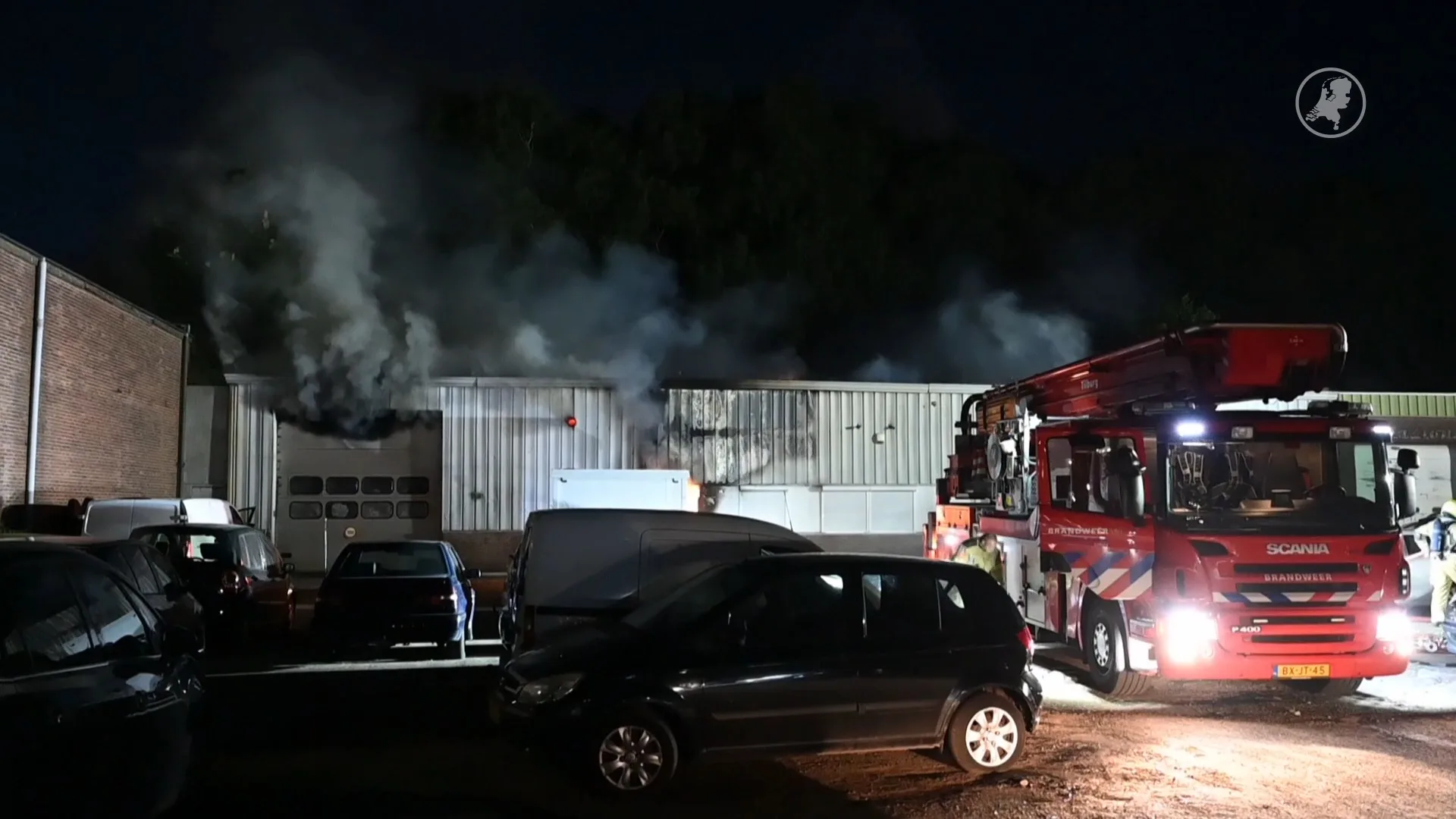 Brandweer moet enorme brand in autobedrijf Tilburg nog uren nablussen