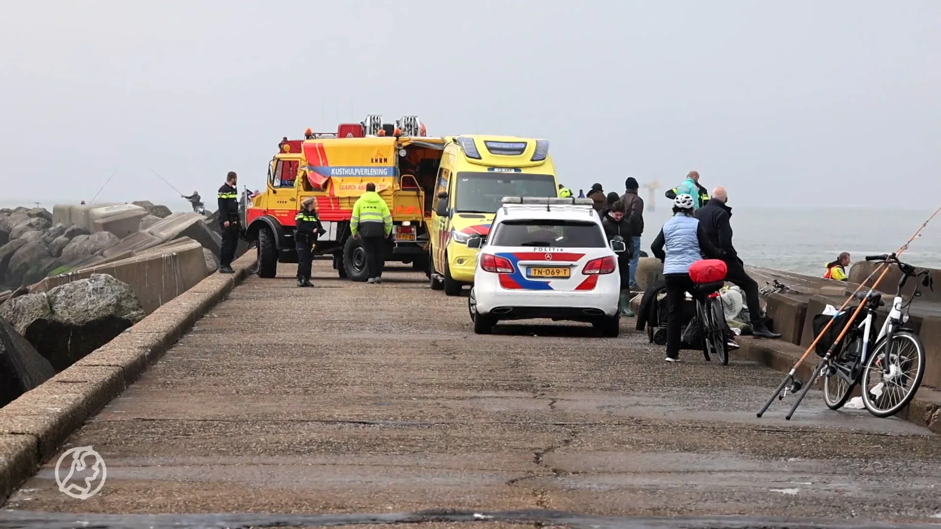 Man vast tussen rotsblokken na val bij pier