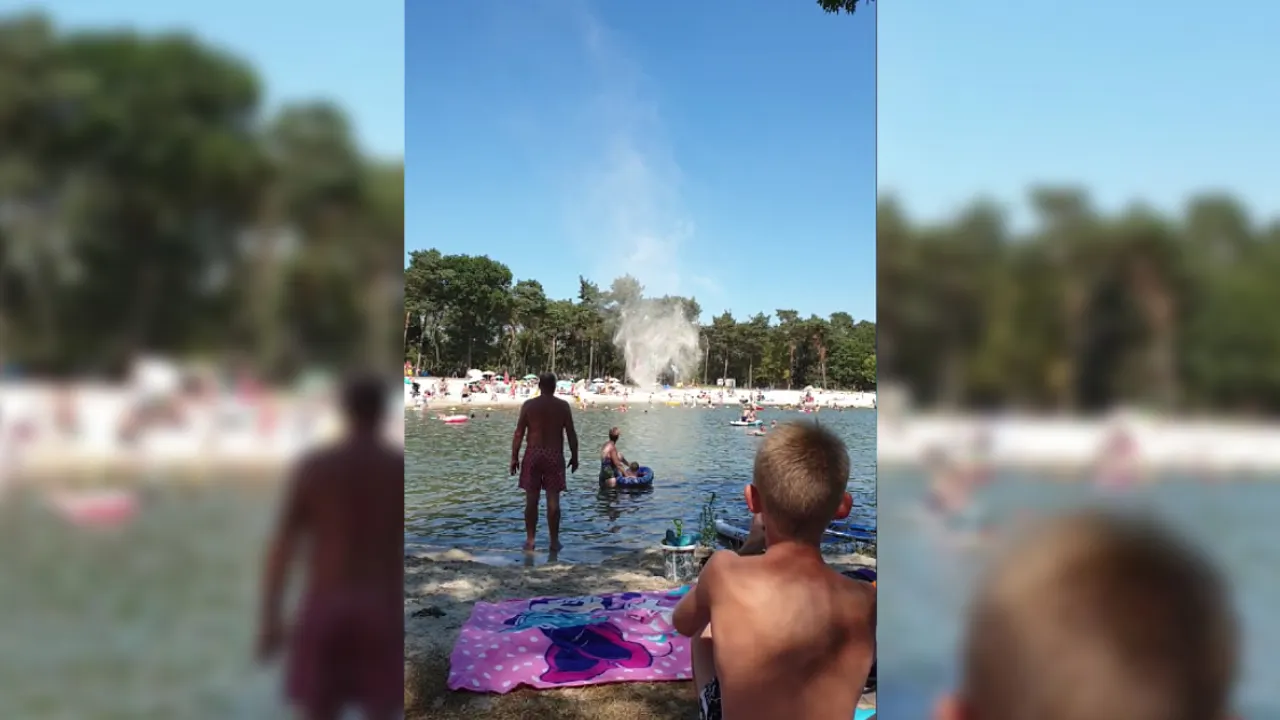 Parasols de lucht in door spectaculaire windhoos bij zwemplas, paniek bij vakantiegangers