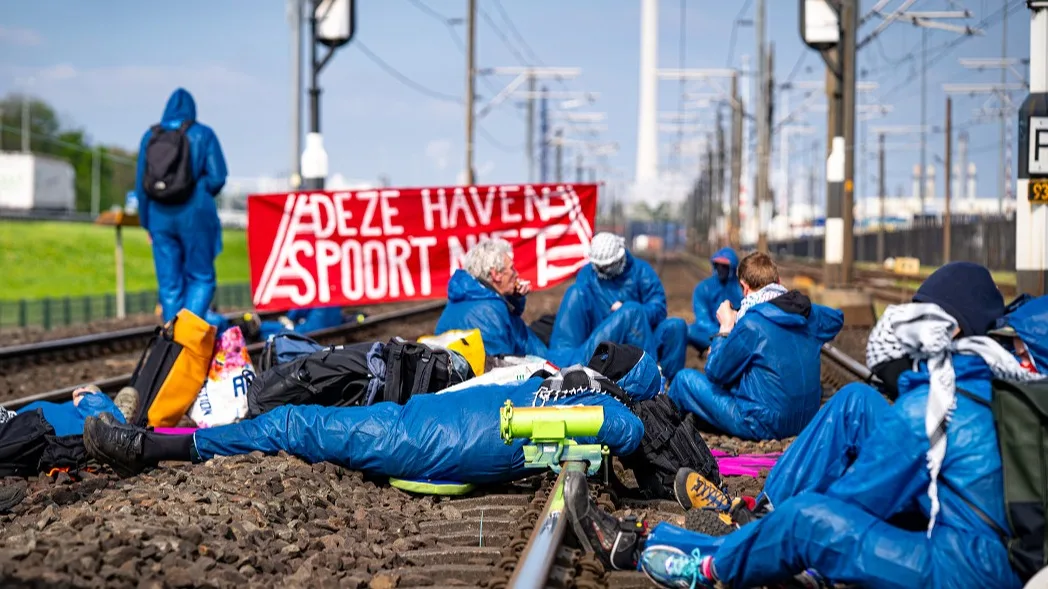 Actievoerders Geef Tegengas ketenen zich vast aan spoor bij Rotterdam
