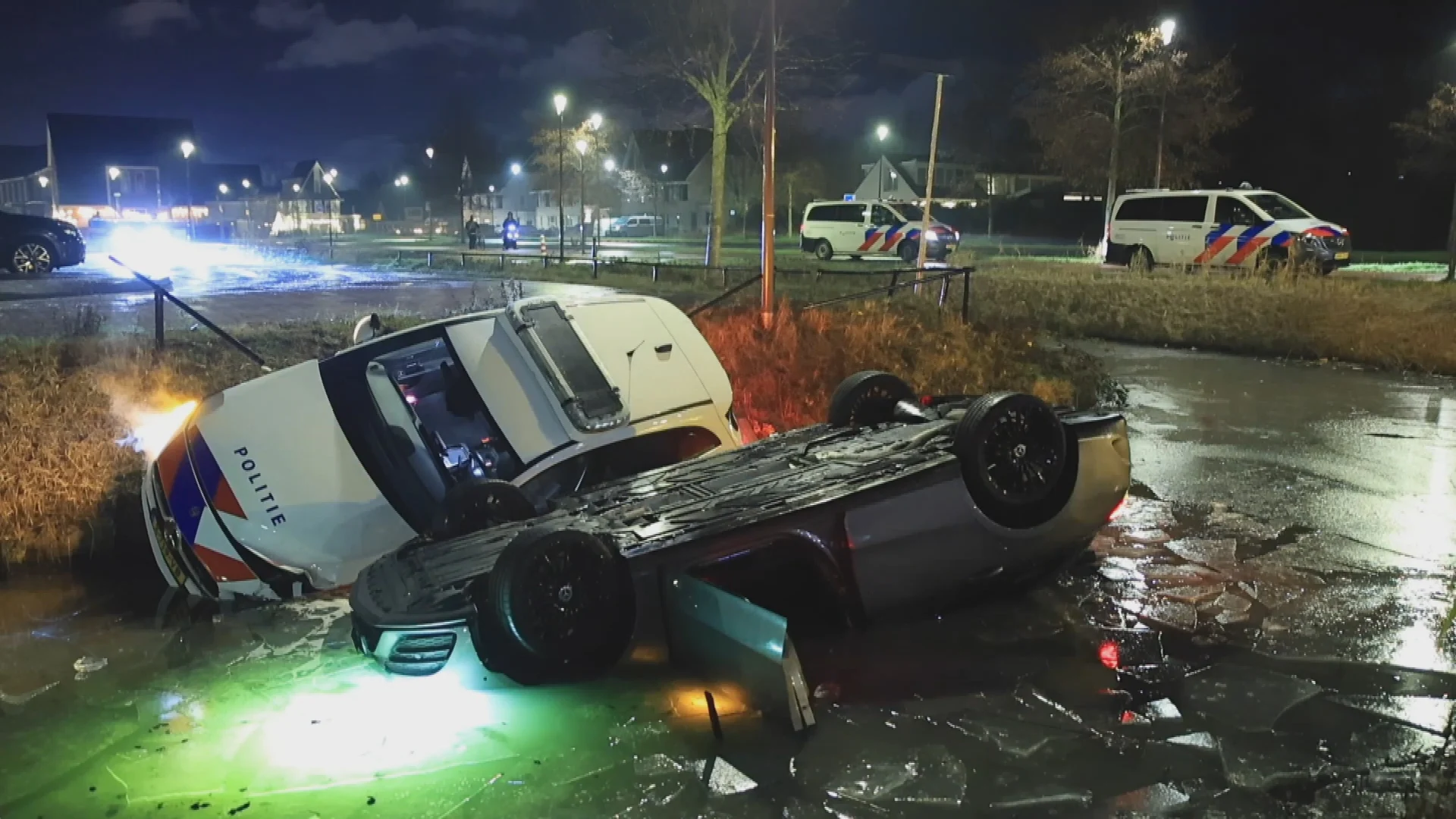 Politiewagen glijdt weg en komt naast auto in sloot Rijswijk terecht