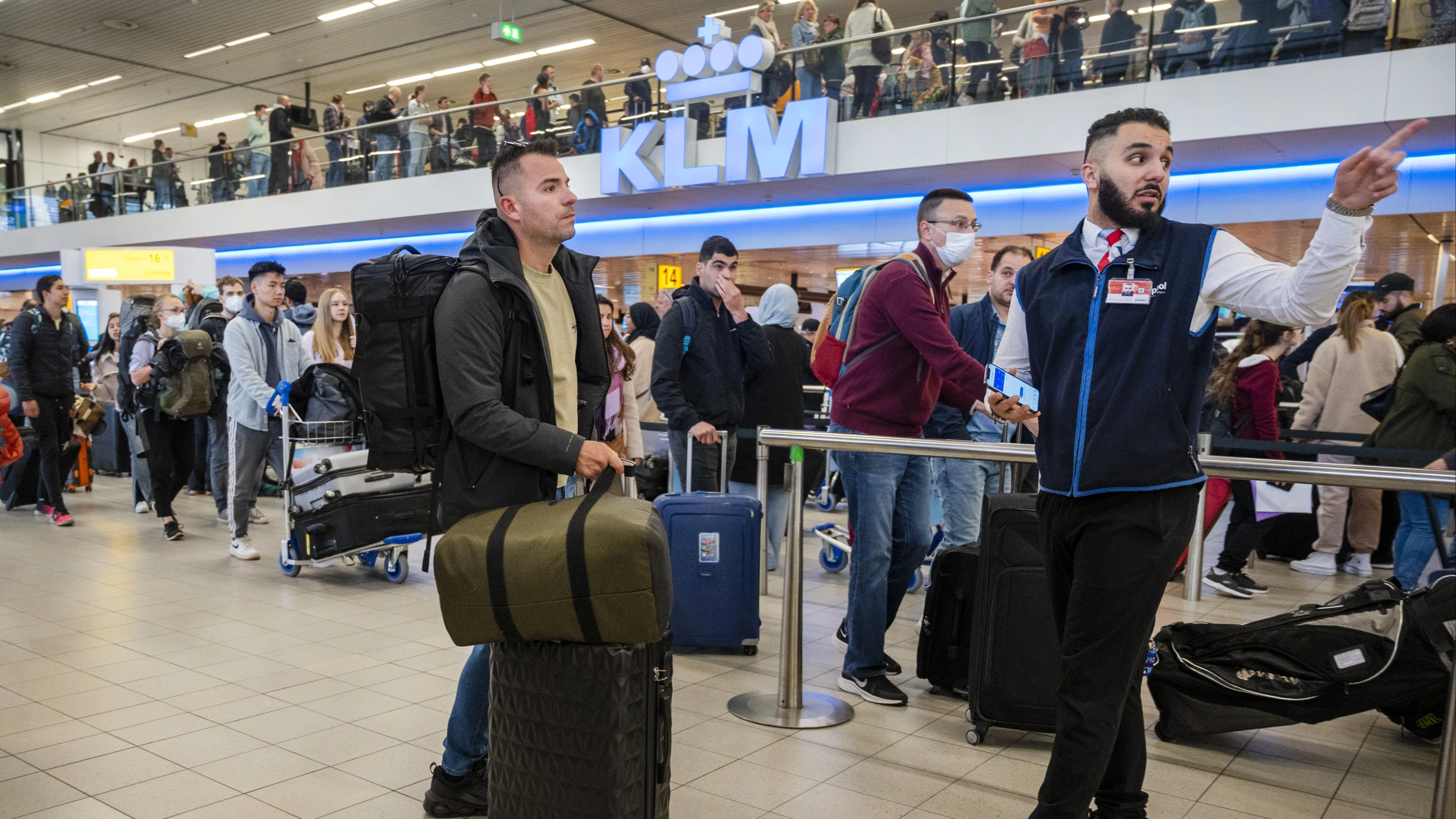 Brandweer deelt water uit aan wachtende mensen op druk Schiphol
