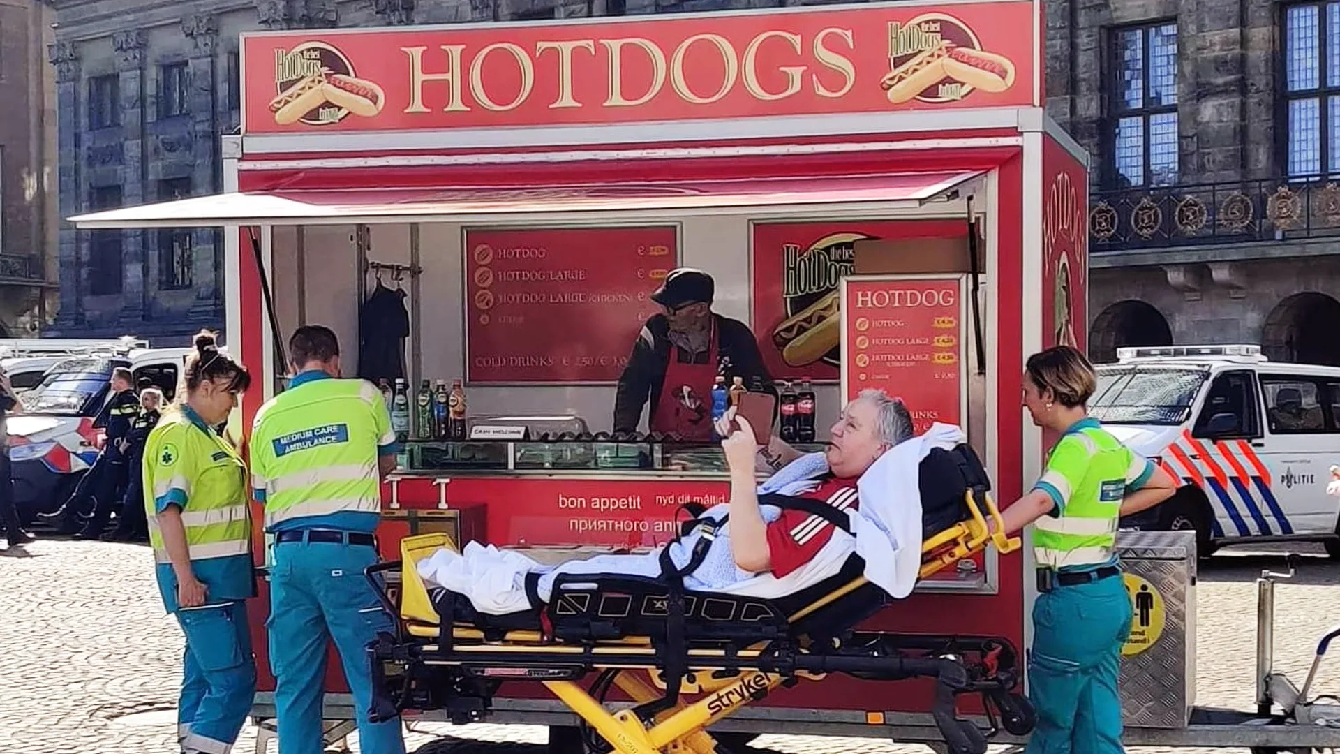 Ambulancepersoneel trakteert patiënt op hotdog in het zonnetje
