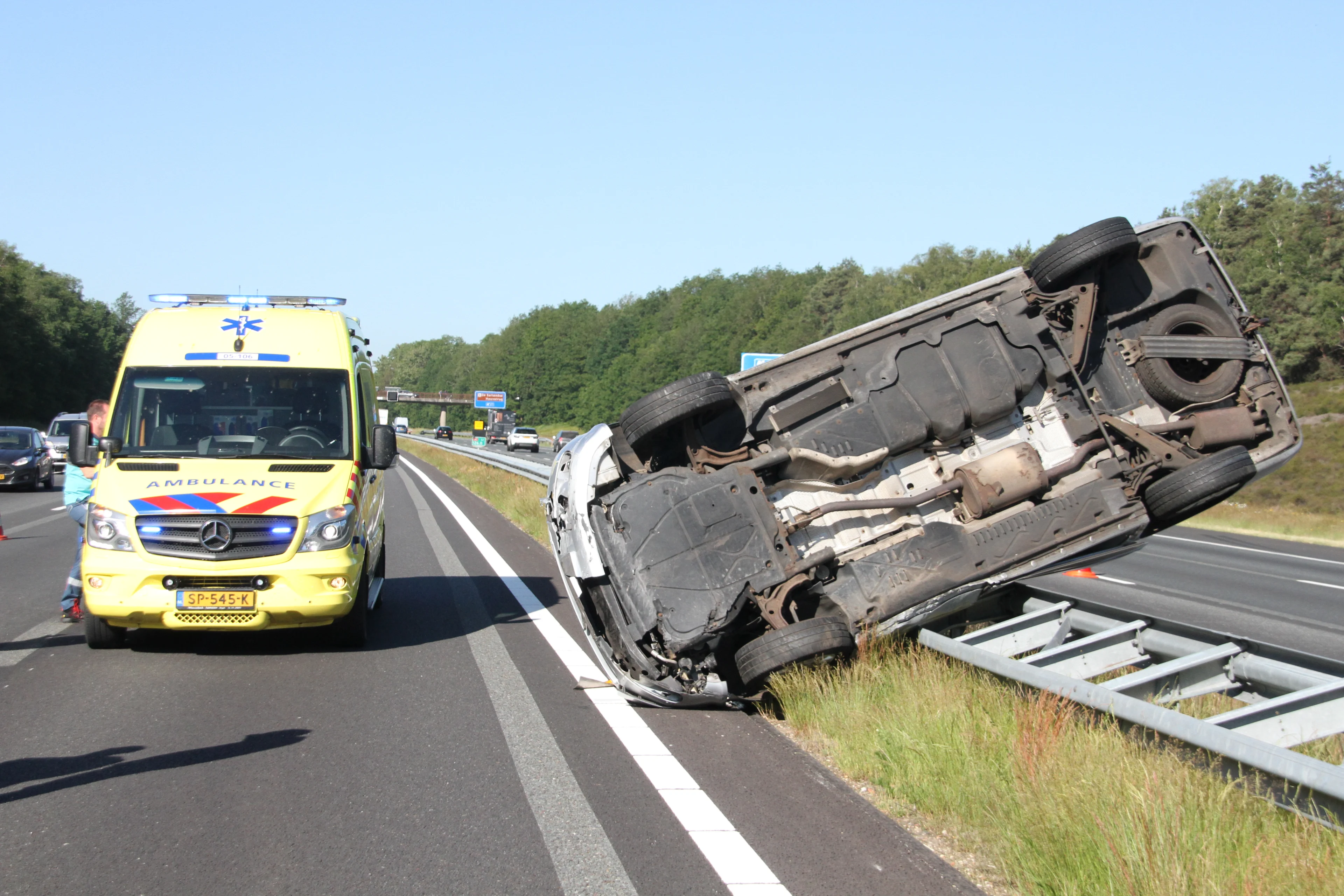 Busje belandt ondersteboven op vangrail A1 na harde botsing