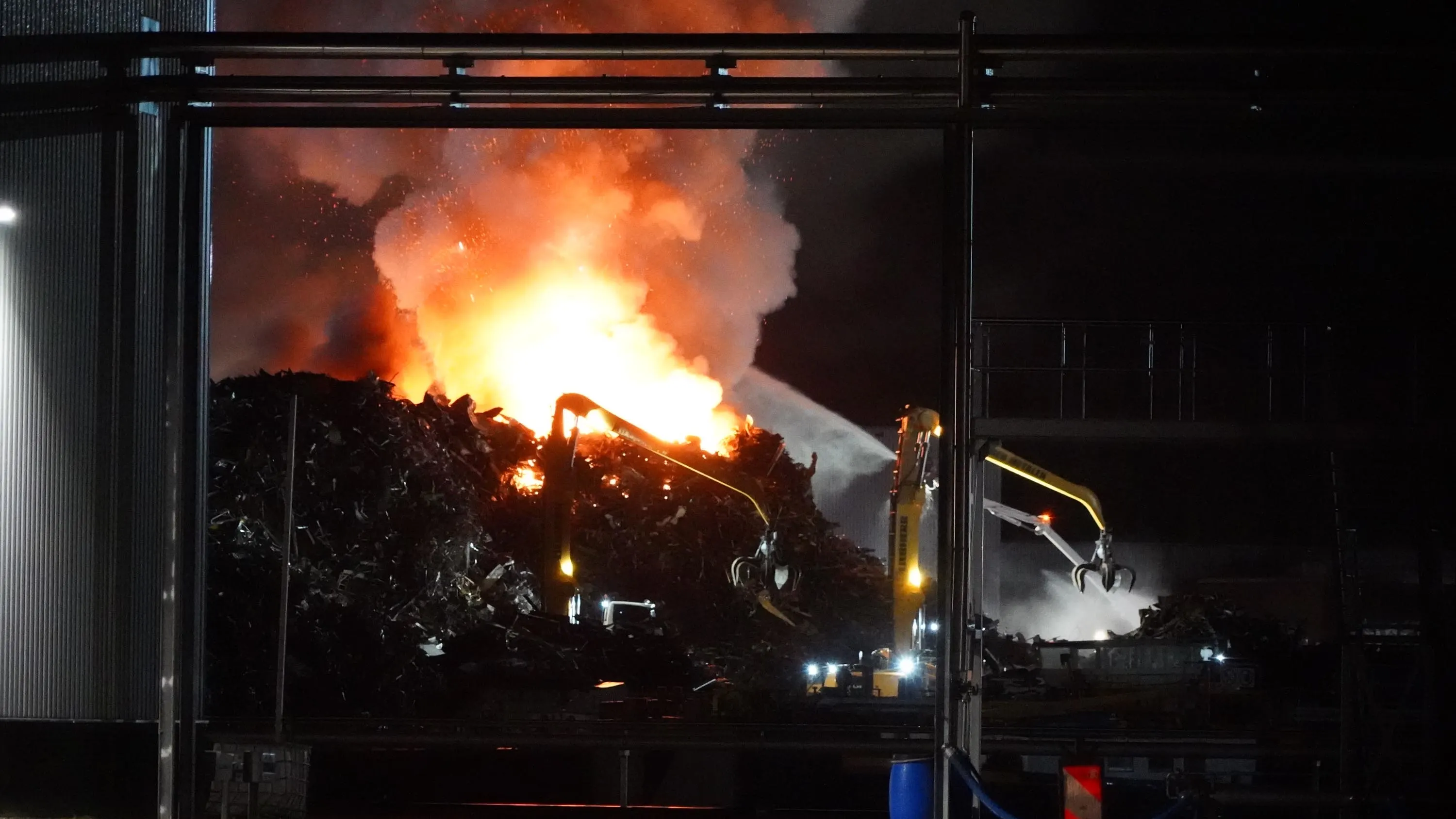 Grote brand in afvalhoop bij metaalbedrijf in Kampen, rook trekt over huizen