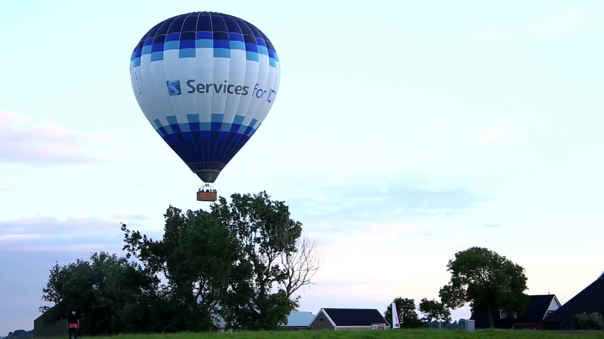 Luchtballon scheert langs woningen en landt in weiland