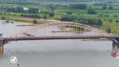 De wandelaars lopen over de Waalbrug