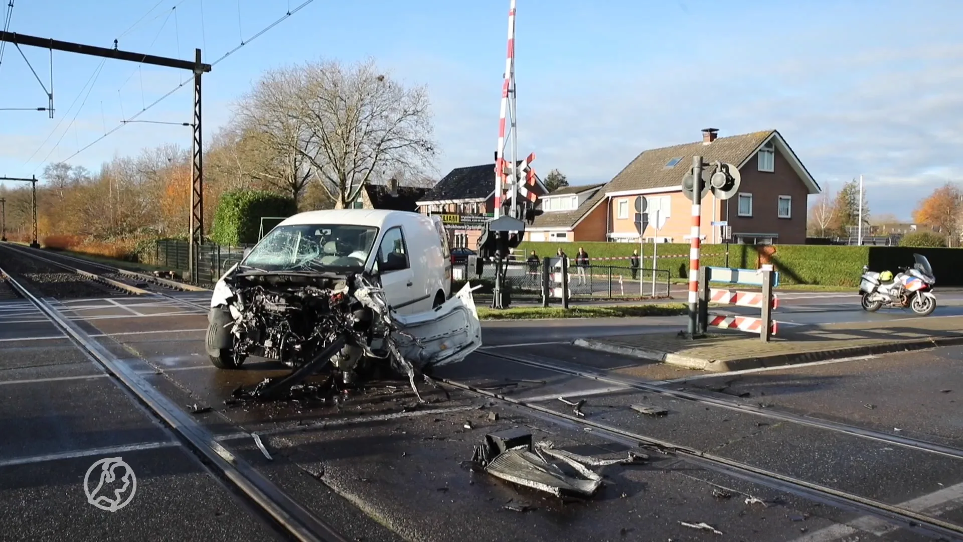 Bestelbus uiteengereten door botsing met trein, bestuurder stapt levend uit