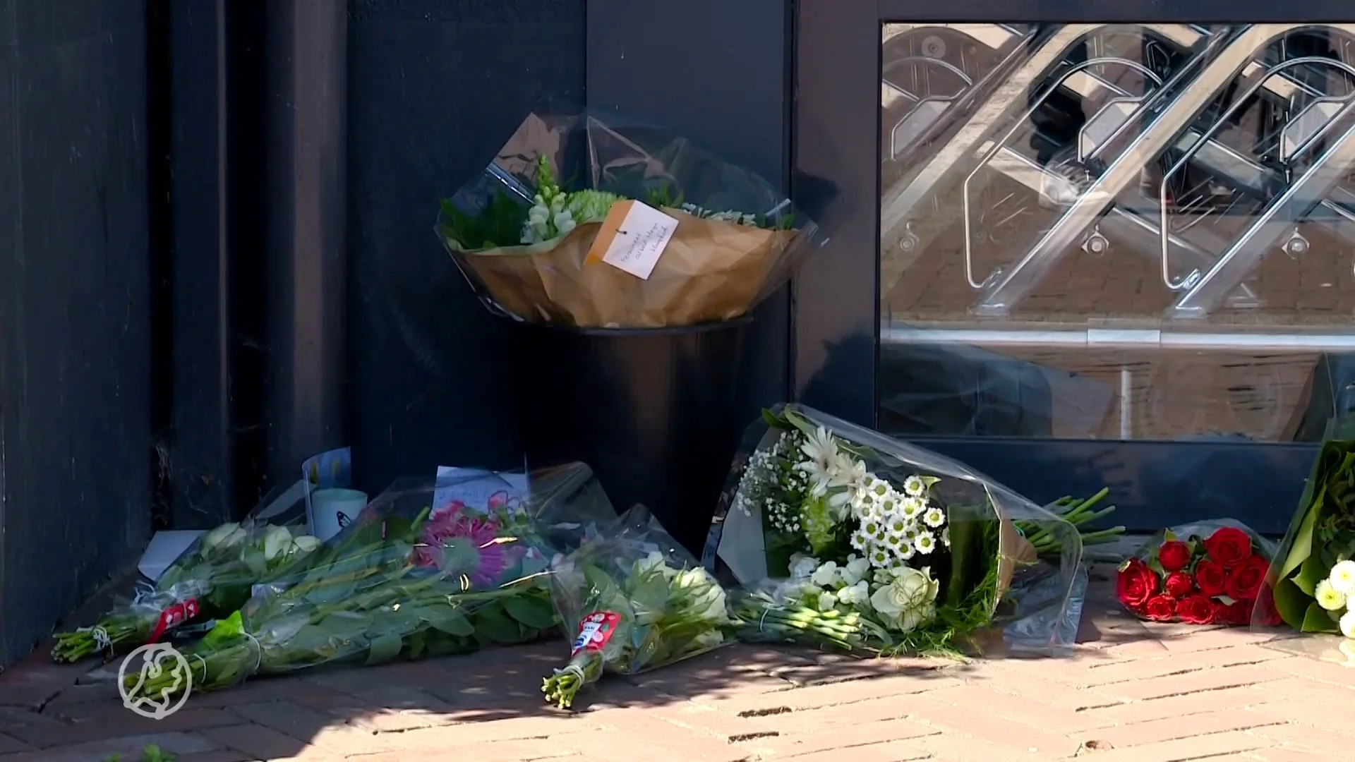 Verslagen dorpelingen leggen bloemen bij supermarkt in Hoogke...