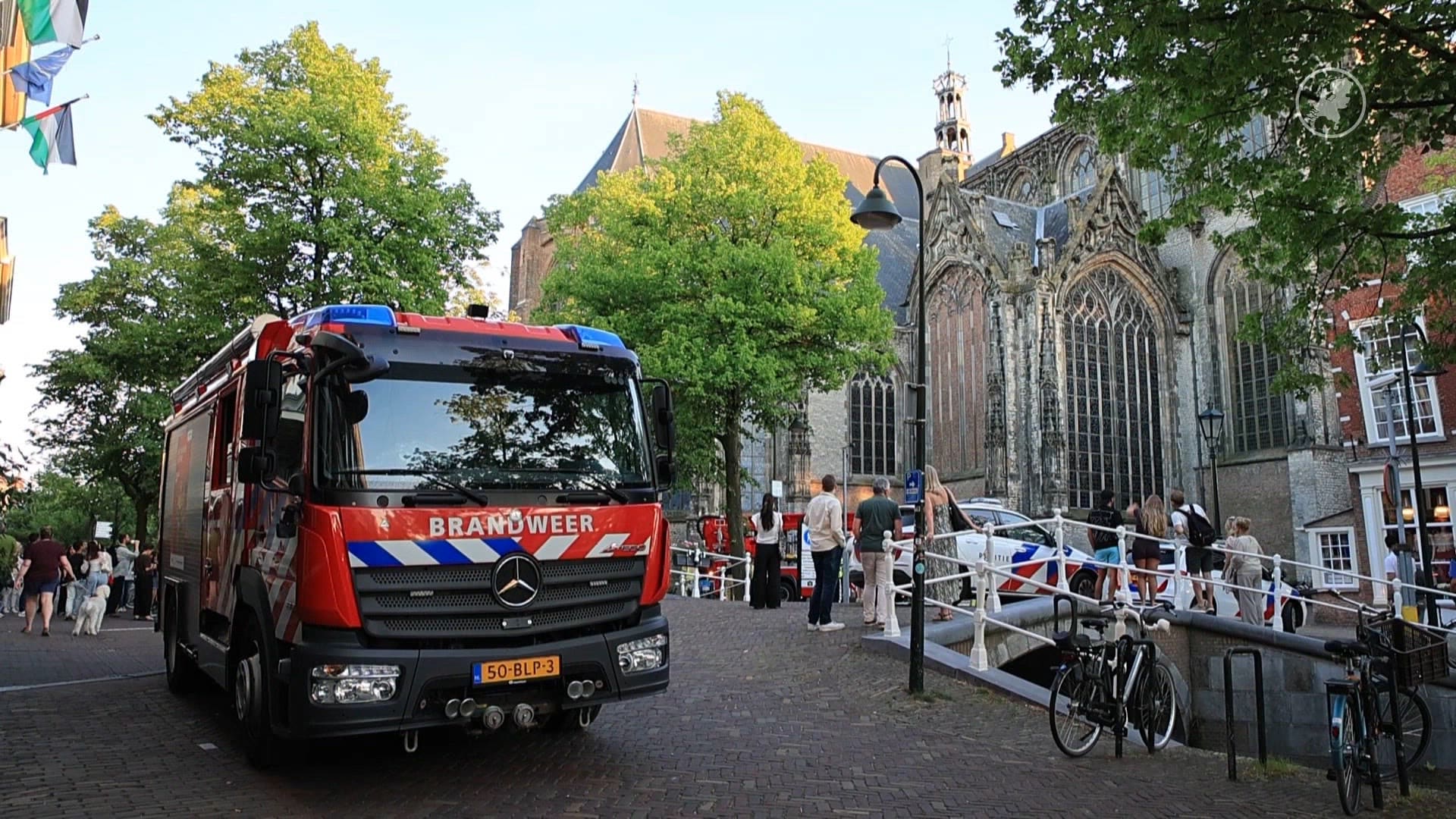 Man klimt dak van Oude Kerk Delft op, hulpdiensten ter plaatse