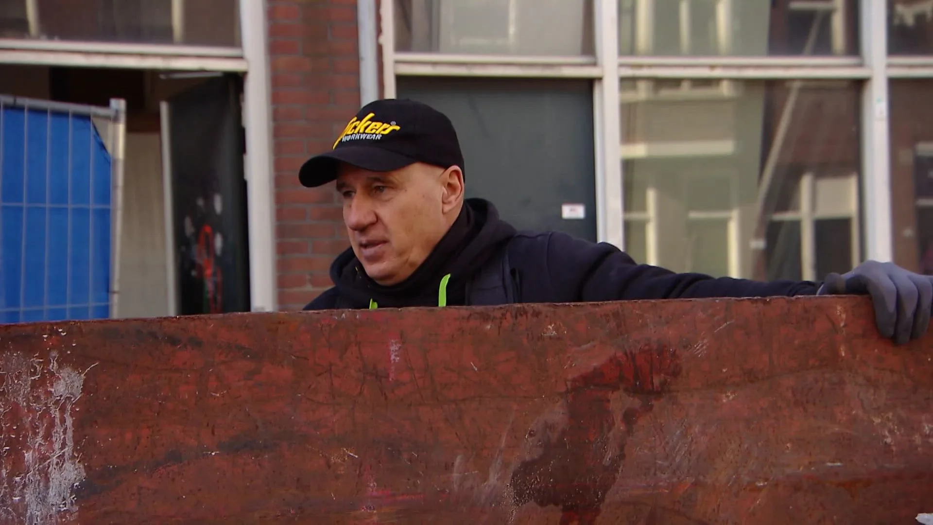 Ray spreekt de groep aan op de container