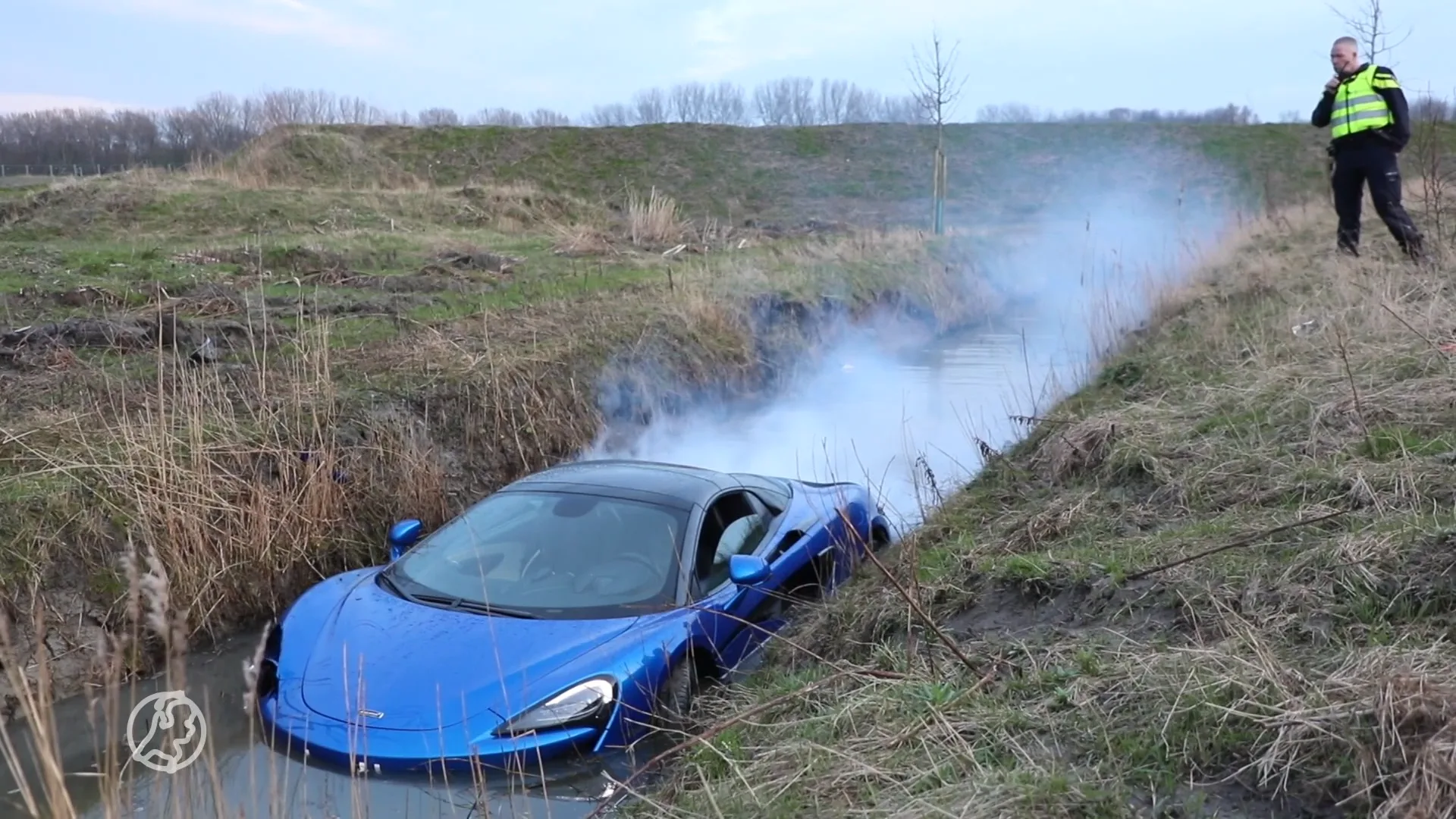 Sportauto schiet uit de bocht en belandt met rokende motor in het water