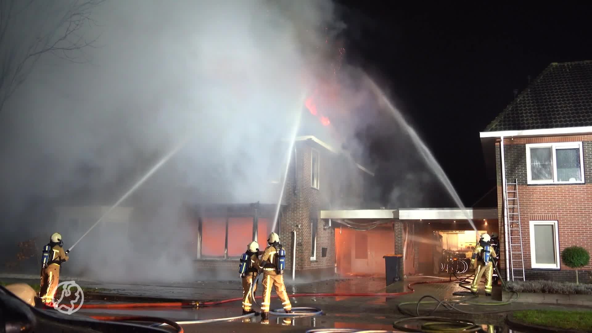 Vrouw klimt met baby uit raam van brandende woning