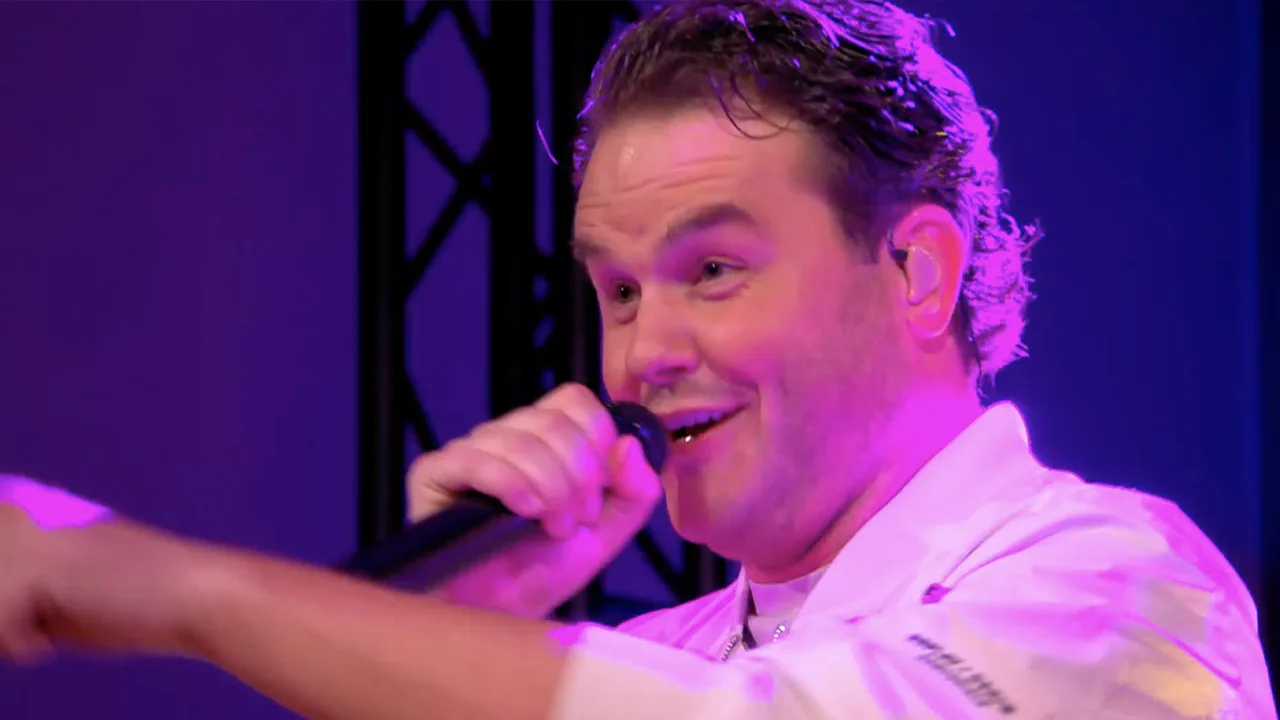 Henk Dissel zorgt in reclamebreak De Oranjezomer voor kroegsfeer in de studio met 'Het Cafeetje!'