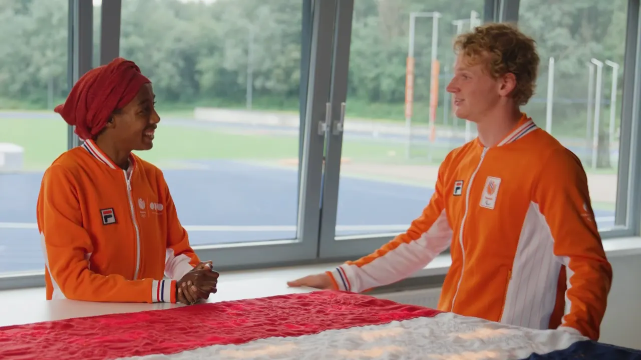 Prachtig! Sifan Hassan draagt Nederlandse vlag over aan Joël de Jong