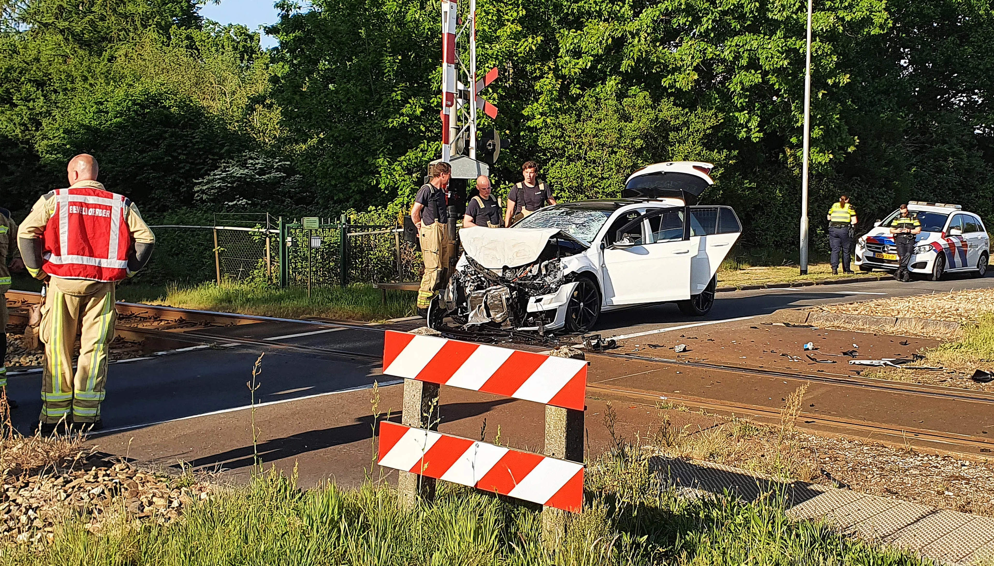 Automobilist rijdt door spoorboom en botst op passerende trein