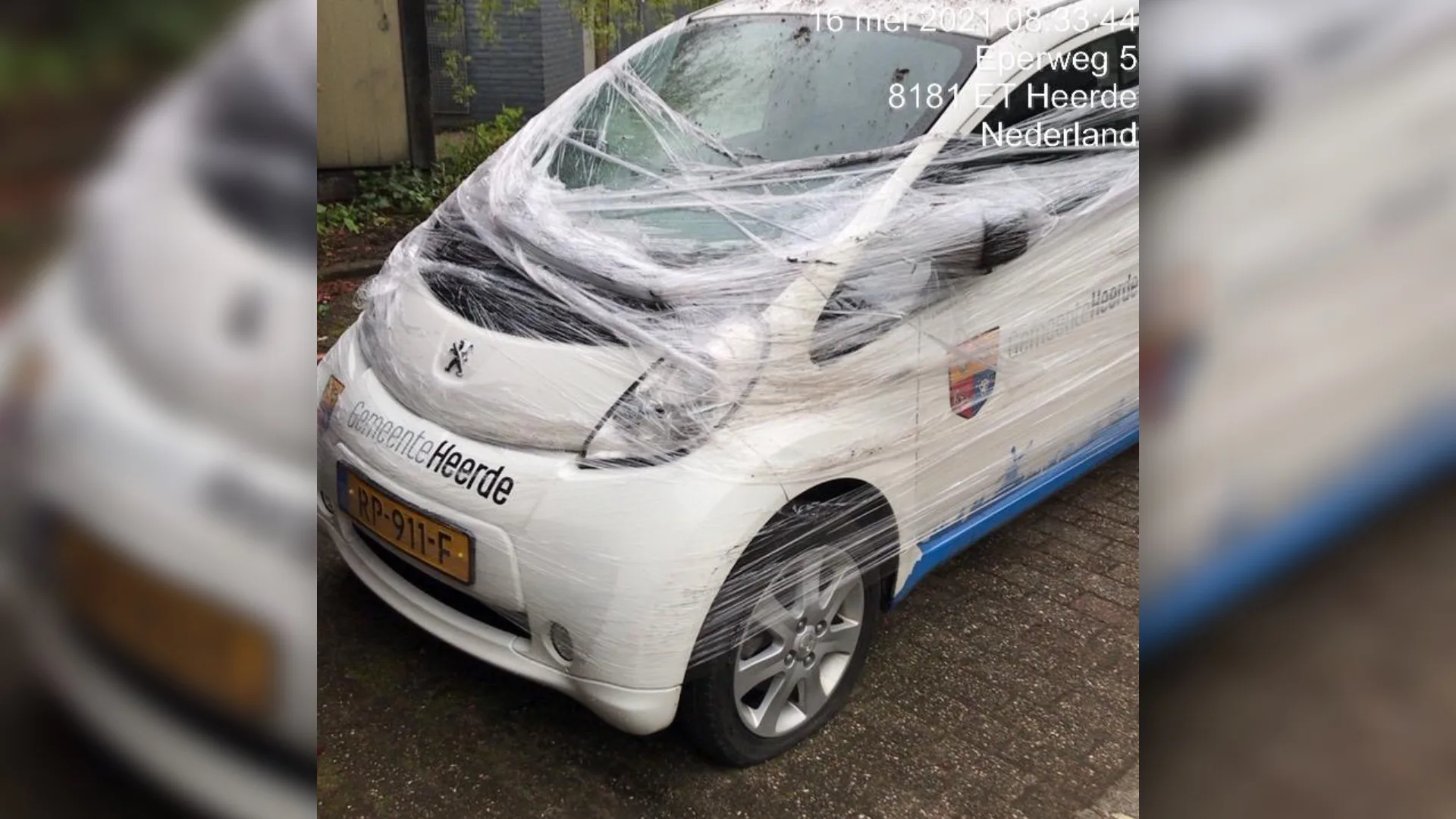 Dienstauto gemeente Heerde omwikkeld in plastic folie, alle banden lek gestoken