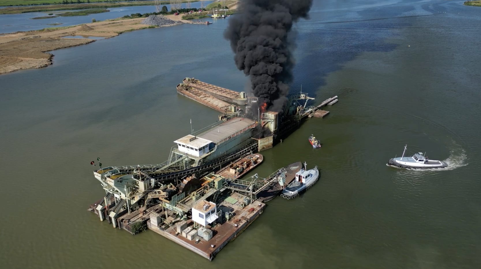 Bemanningsleden brandend baggerschip veilig, vuur onder controle