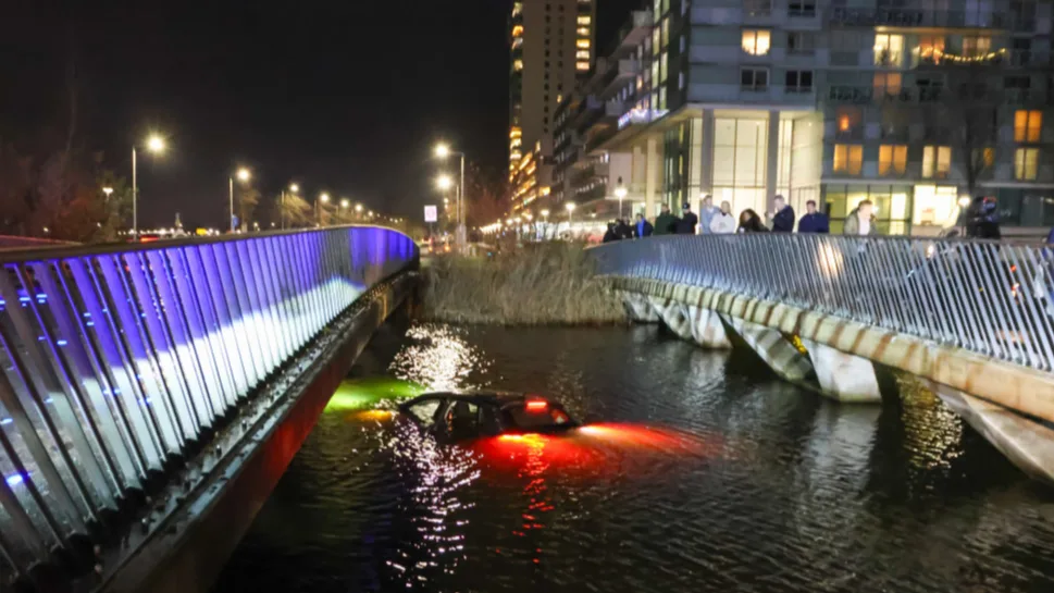 Auto met twee jonge kinderen rijdt water in, omstander helpt