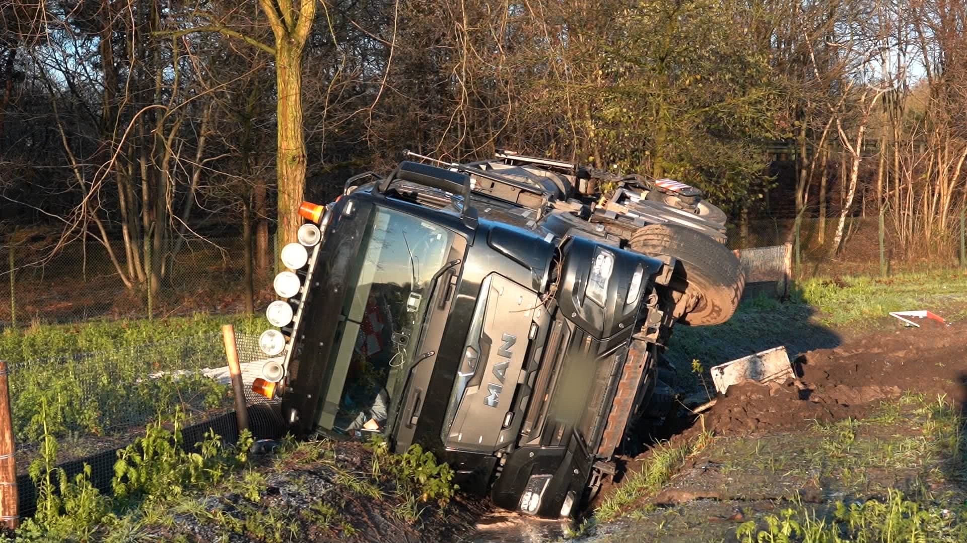 Zelfs strooiwagen niet bestand tegen gladheid, ligt op z'n kant in sloot