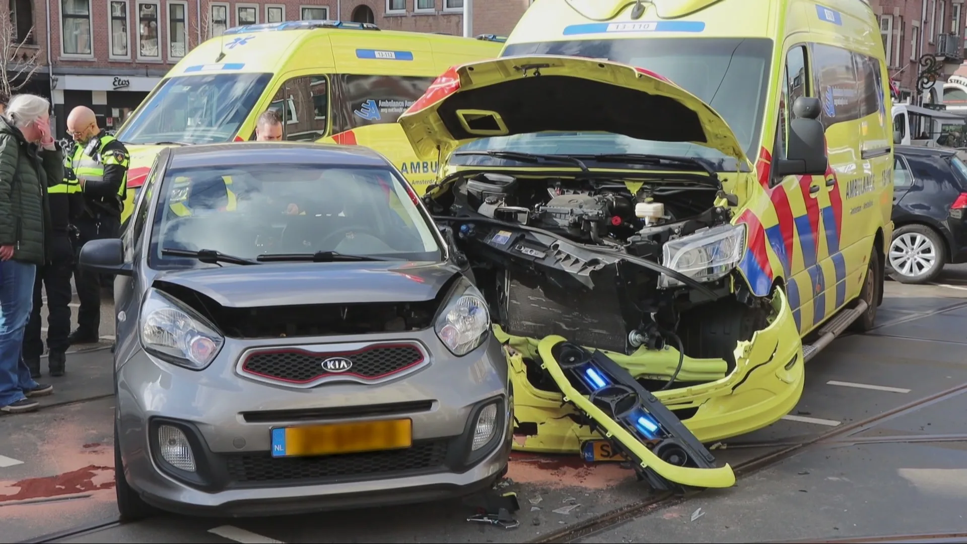 Ambulance botst tijdens spoedrit op auto in Amsterdam, veel schade