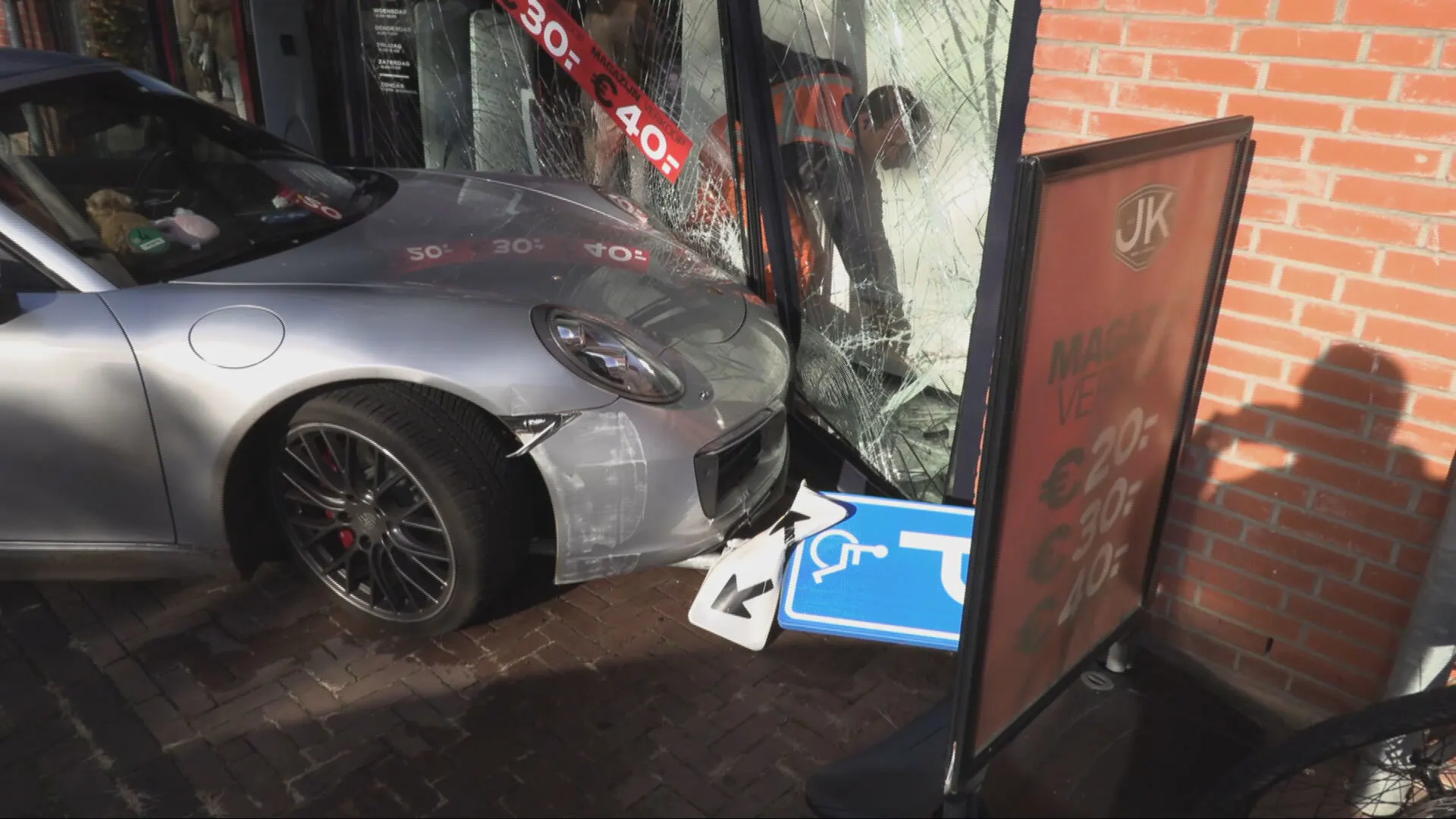 Porsche rijdt pui van winkel in, veel schade tot gevolg