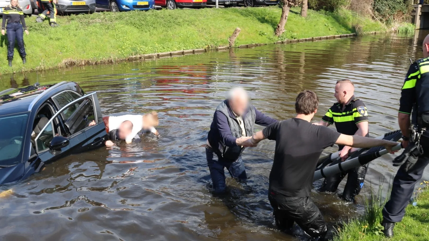 Agent en buurtbewoner redden ouderen uit te water geraakte auto